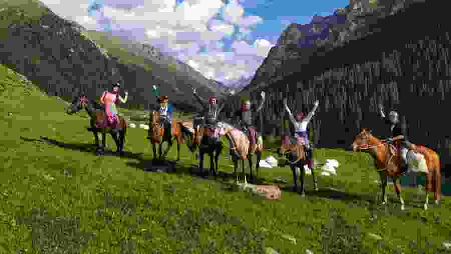 Travelers horse riding in Kyrgyzstan