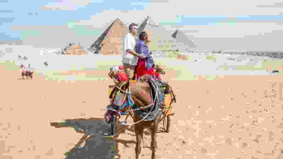 Travelers camel riding at the Giza Necropolis