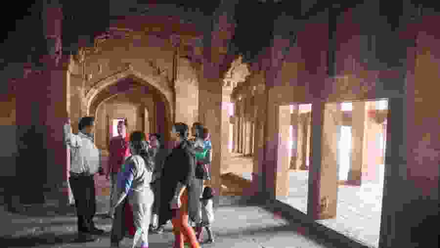Visitors listen to a guide at the palace at Fatehpur Sikri.