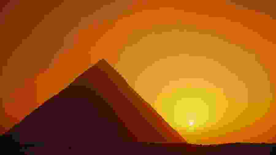 Marvel at the view of the sunset over the Pyramids