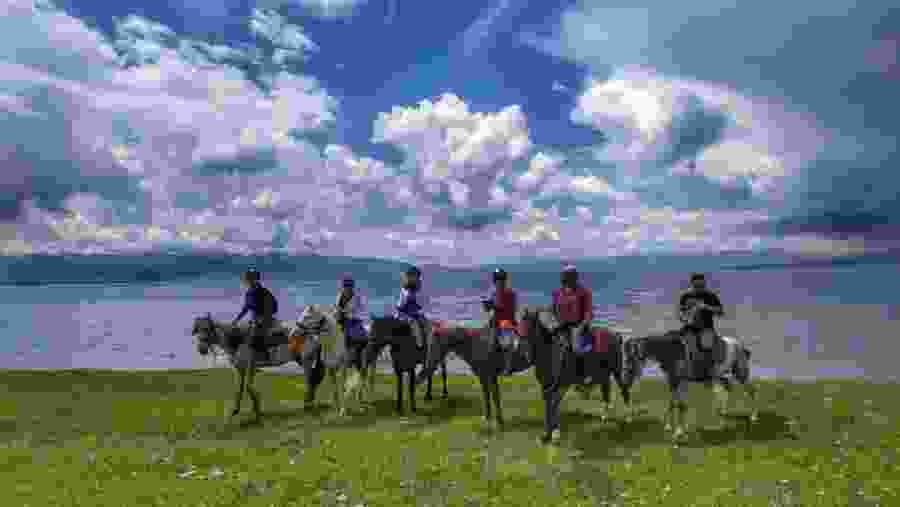 Travelers horse riding in Kyrgyzstan