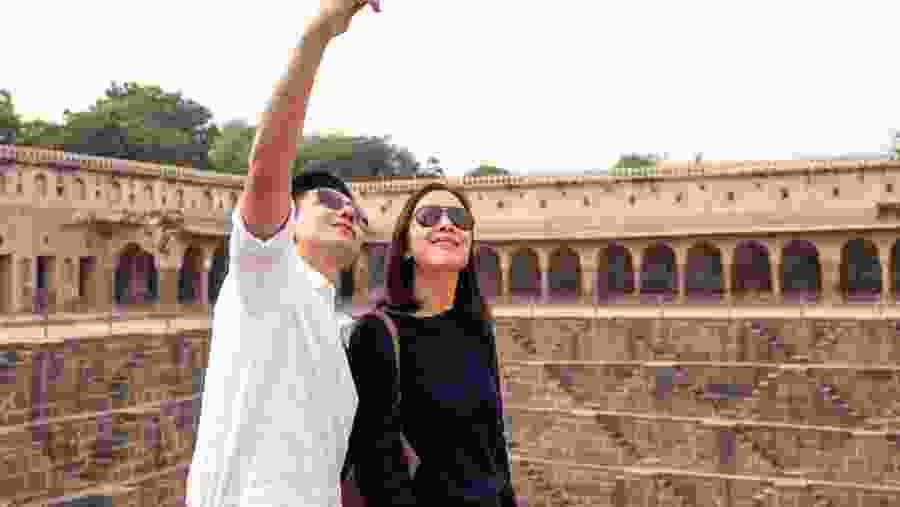 Asian couple happy in love taking selfie photo on Chand Baori stepwell.