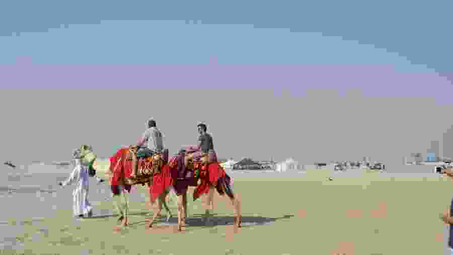 Tourists Enjoying Camel Ride At The Desert