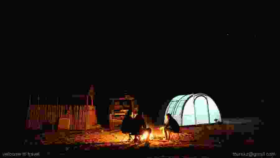 Starry night with campfire in Aktau mountains. Altyn Emel National Park, Kazakhstan