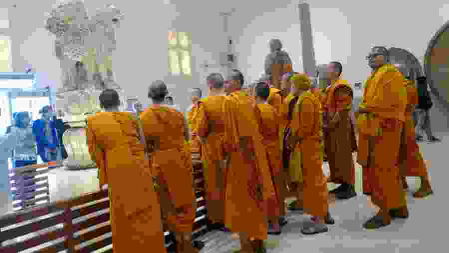 Buddhist monks examine sculptures in the museum at Sarnath near Varanasi.