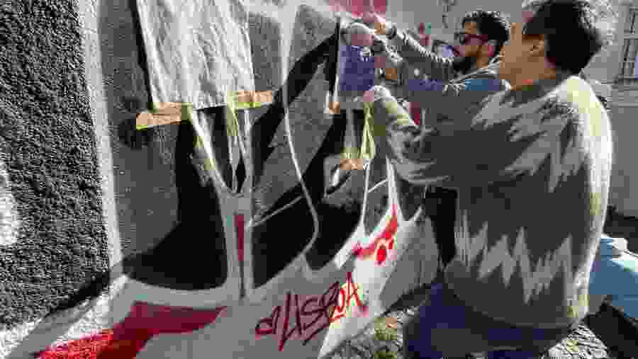 Travelers engaging in street art