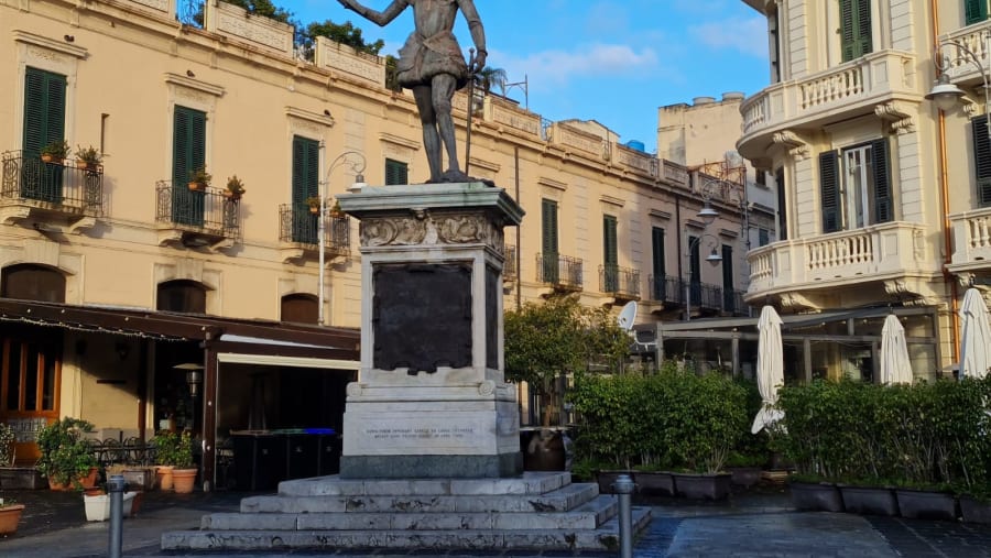 The Don Giovanni bronze statue and its refined palaces at the back