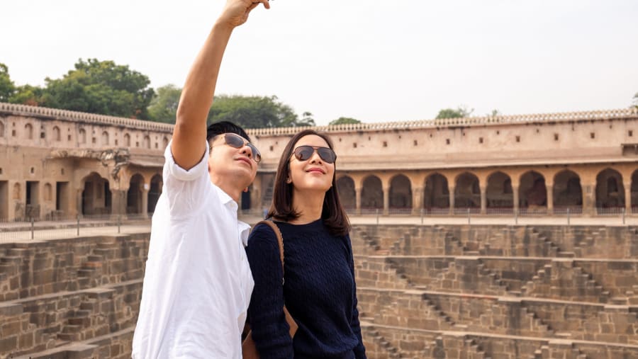 Asian couple happy in love taking selfie photo on Chand Baori stepwell.