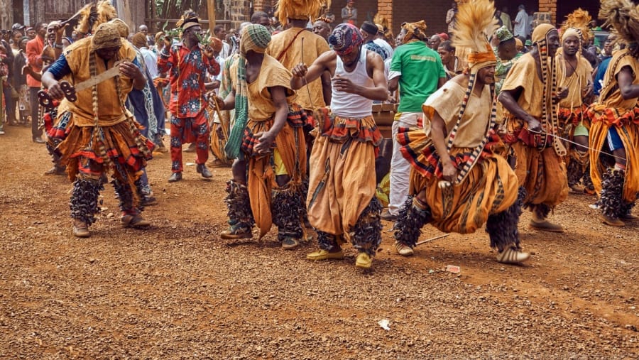 People in Traditional Dress Dancing on Brown Field
