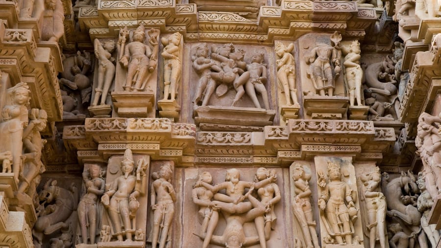Stone carved erotic bas-relief in Hindu temple in Khajuraho, India. Unesco World Heritage Site.