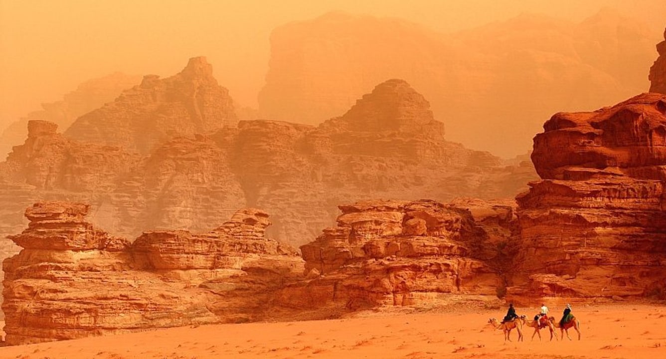 Wadi Rum Visitor Center, towering rock formations, sand dunes