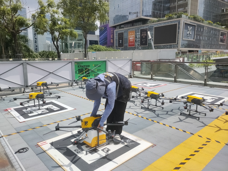 drone launch site, pick-up kiosk in a public park or leisure area, driverless robotaxi ride
