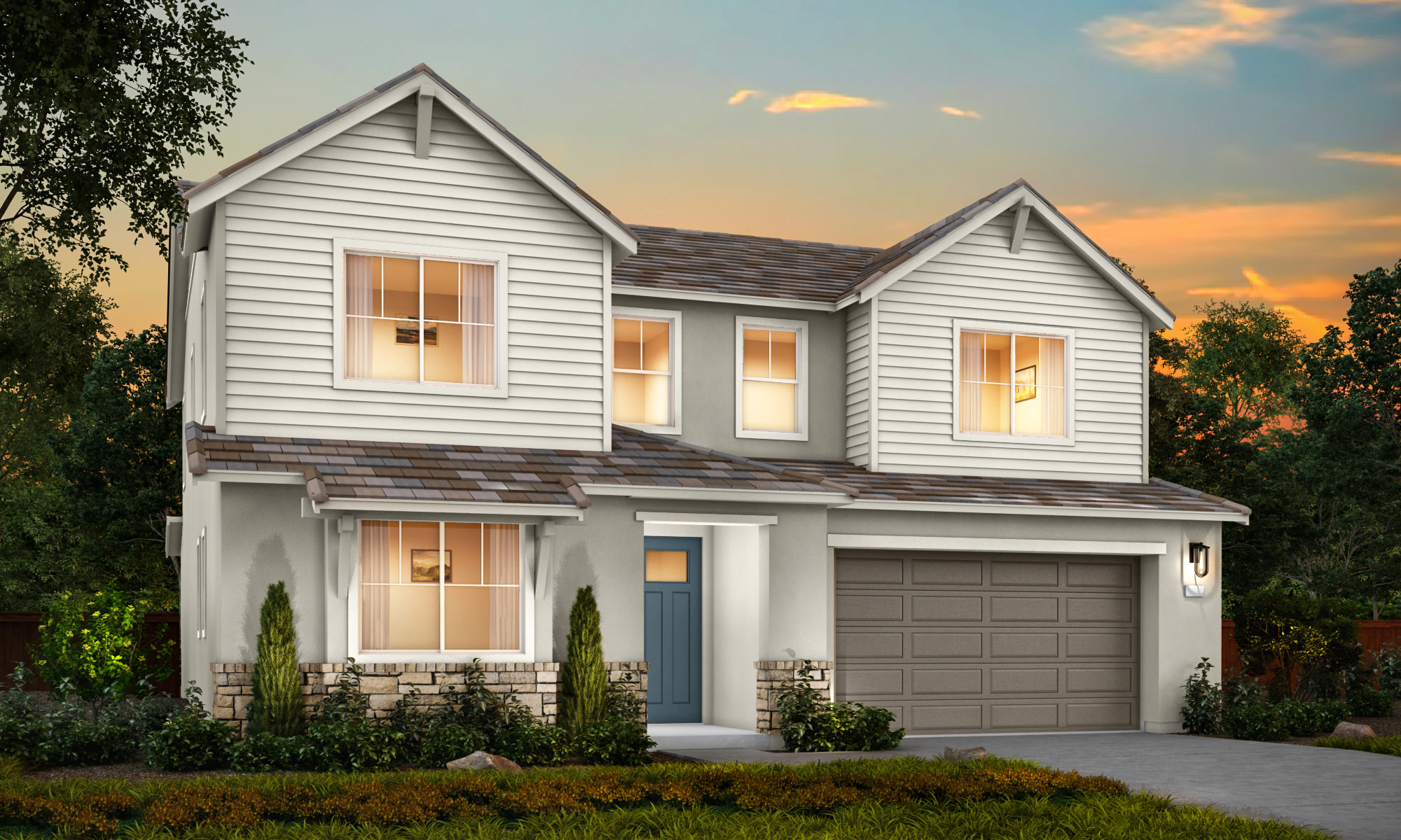 A two-story residential house with a gray exterior, a garage, and a well-landscaped front yard set against a colorful sunset sky.
