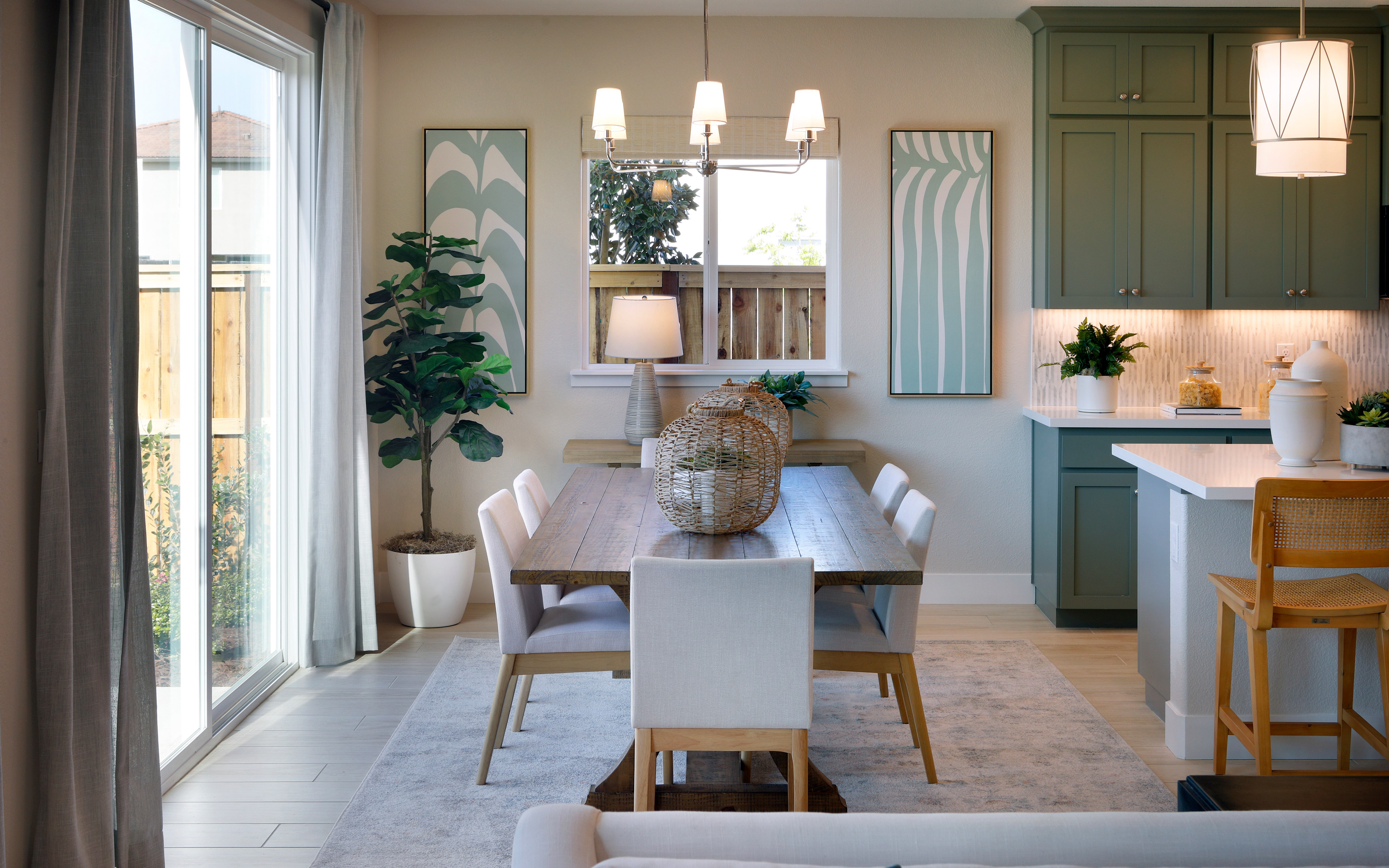 A cozy and well-designed dining area with a wooden table, white chairs, and a green cabinet in the background, complemented by various decorative elements and natural lighting from the windows.