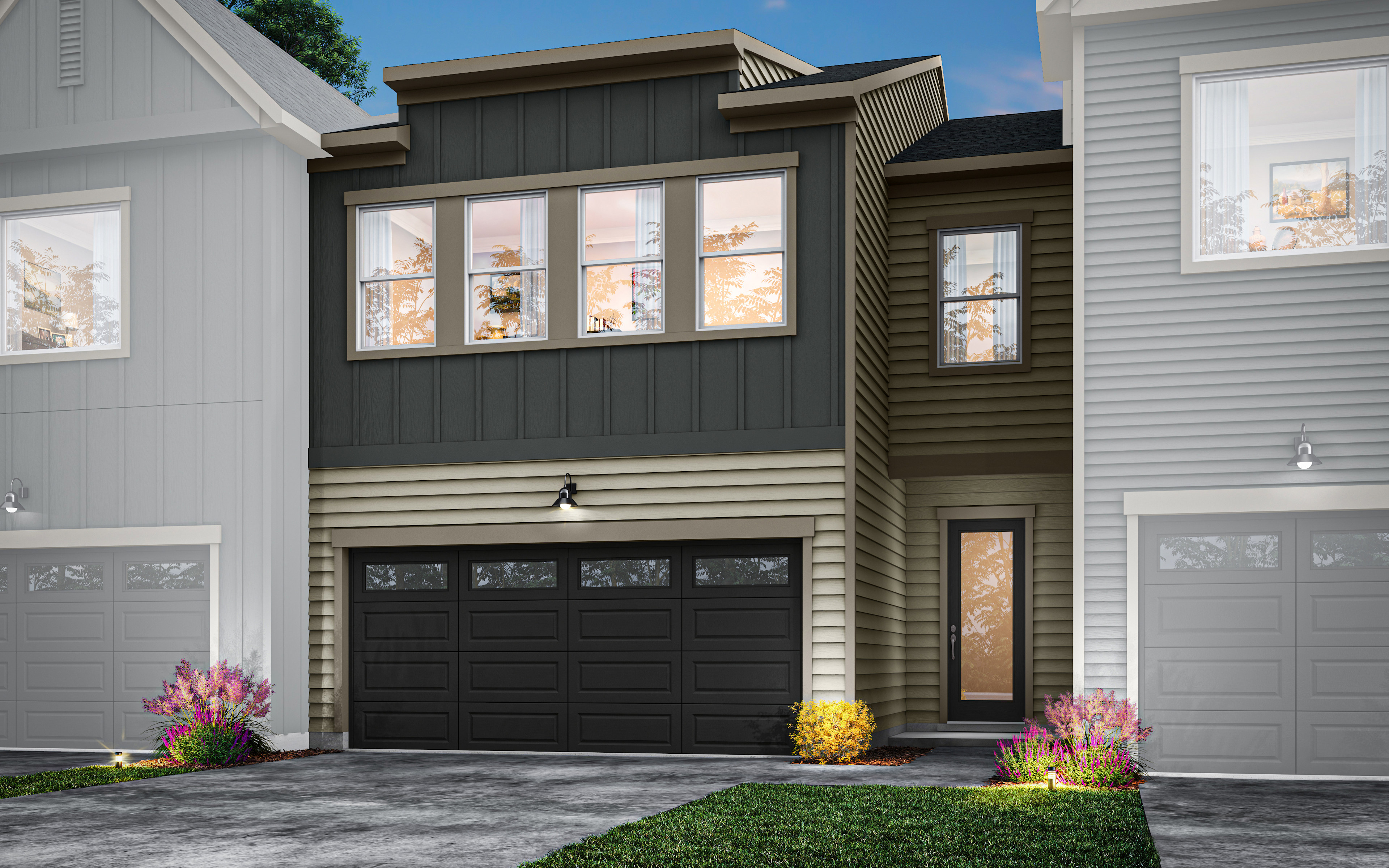 A modern two-story townhouse with a black garage door, large windows, and a landscaped front yard with colorful flowers.