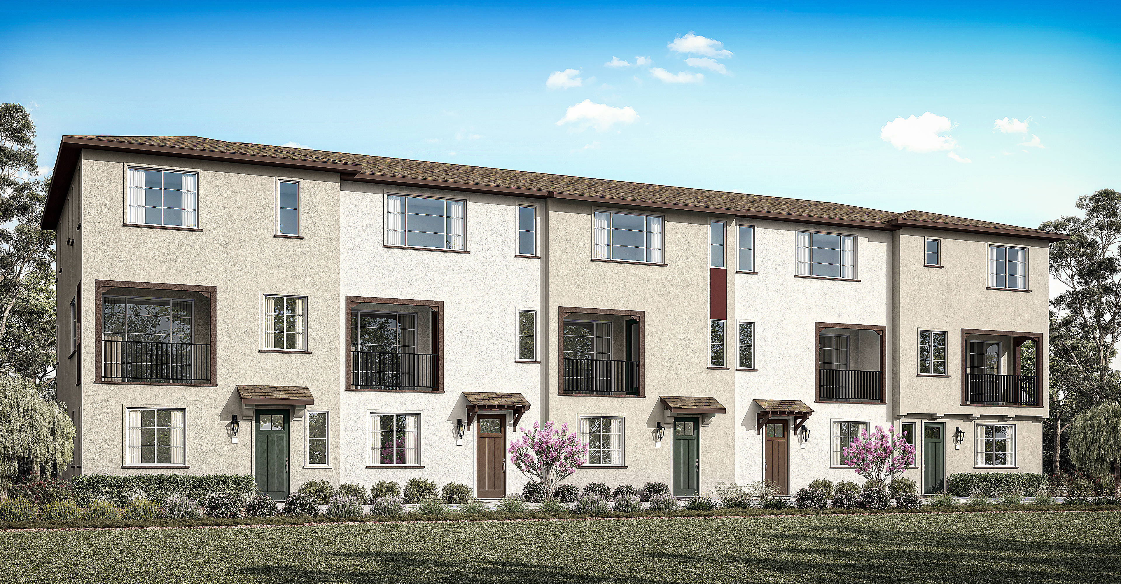 A multi-story residential building with a grassy foreground, surrounded by trees and a clear blue sky.