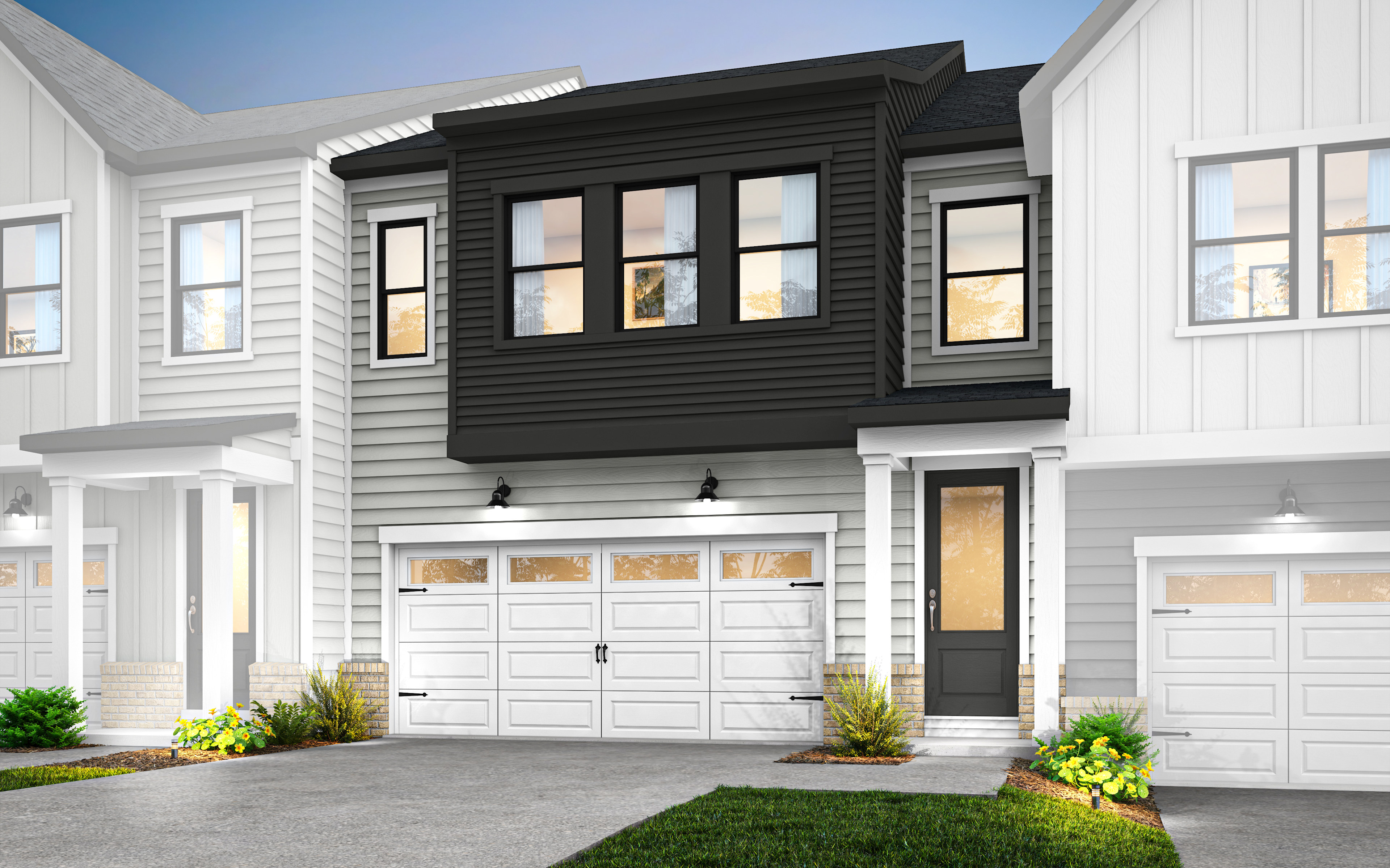 A modern townhouse with a white exterior, black trim, and a two-car garage stands in a well-manicured yard with lush greenery in the foreground.