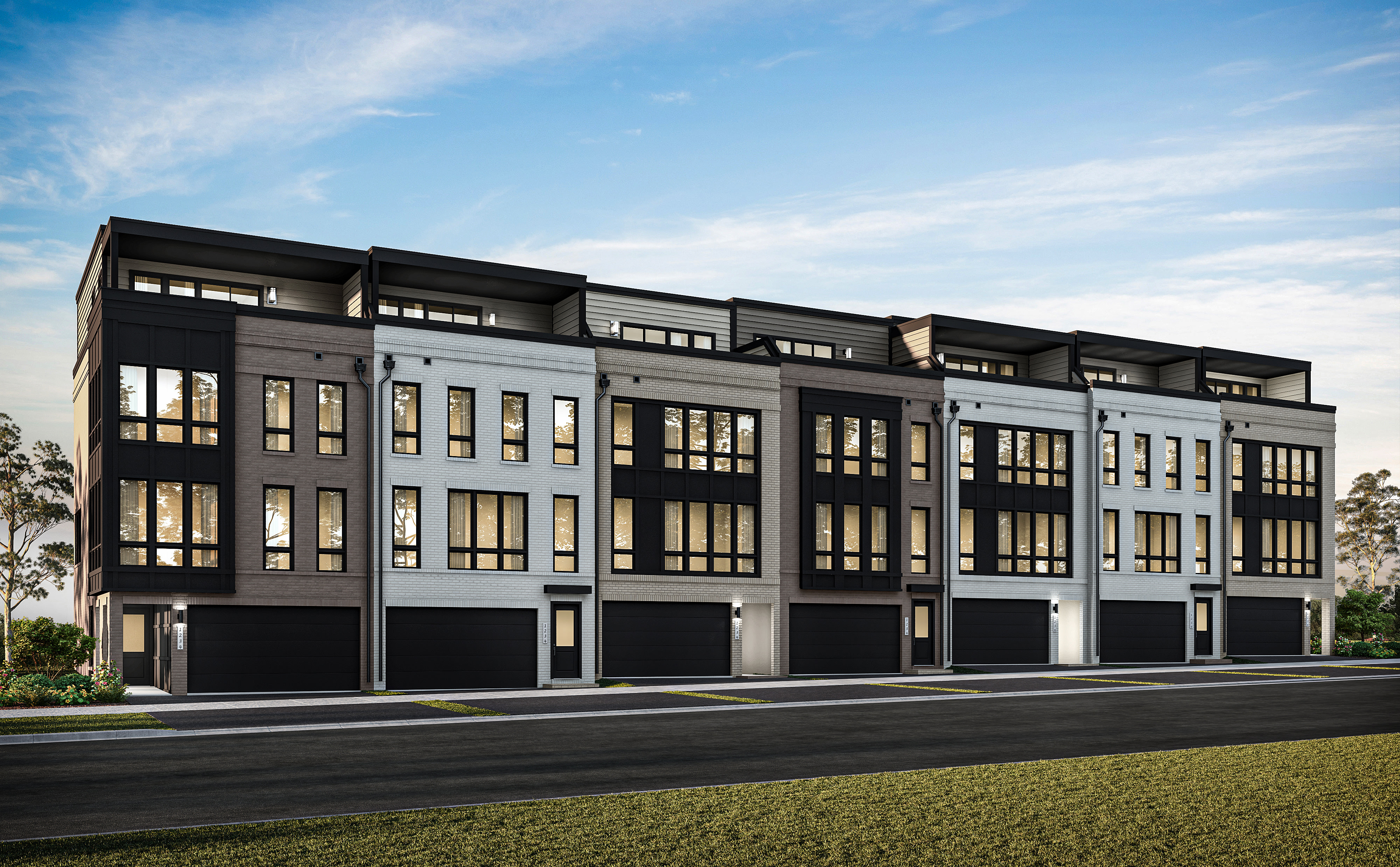 A modern multi-story residential building with a sleek, contemporary design stands against a backdrop of a clear blue sky with wispy clouds.