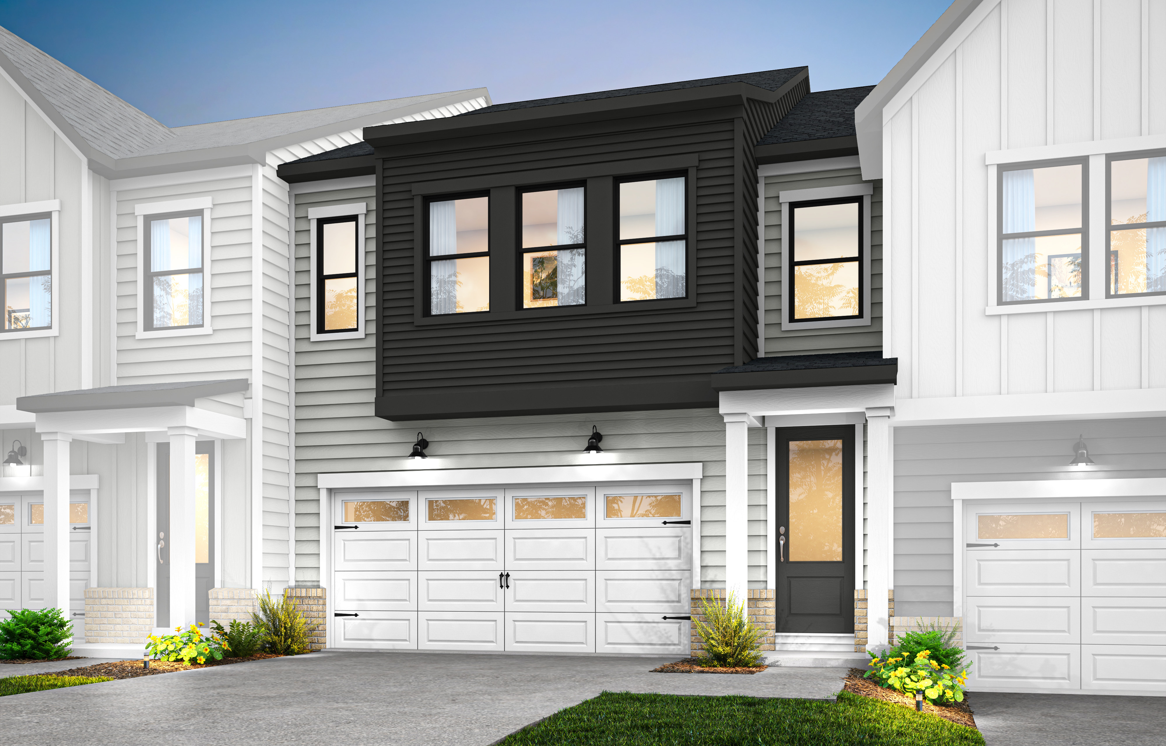 A modern townhouse with a white exterior, black trim, and a two-car garage stands in a well-manicured yard with lush greenery in the foreground.