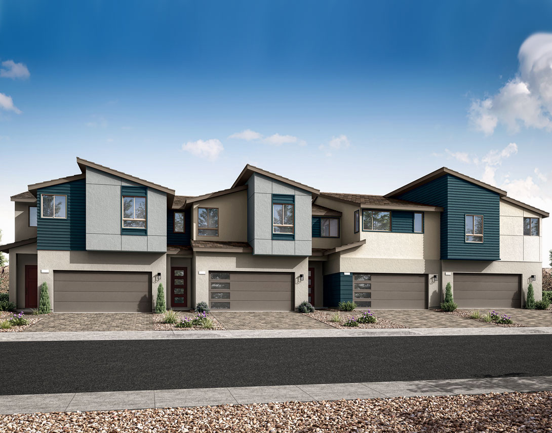 A row of modern, multi-story townhouses with a mix of neutral and vibrant colors, set against a clear blue sky with scattered clouds, and a paved driveway in the foreground.