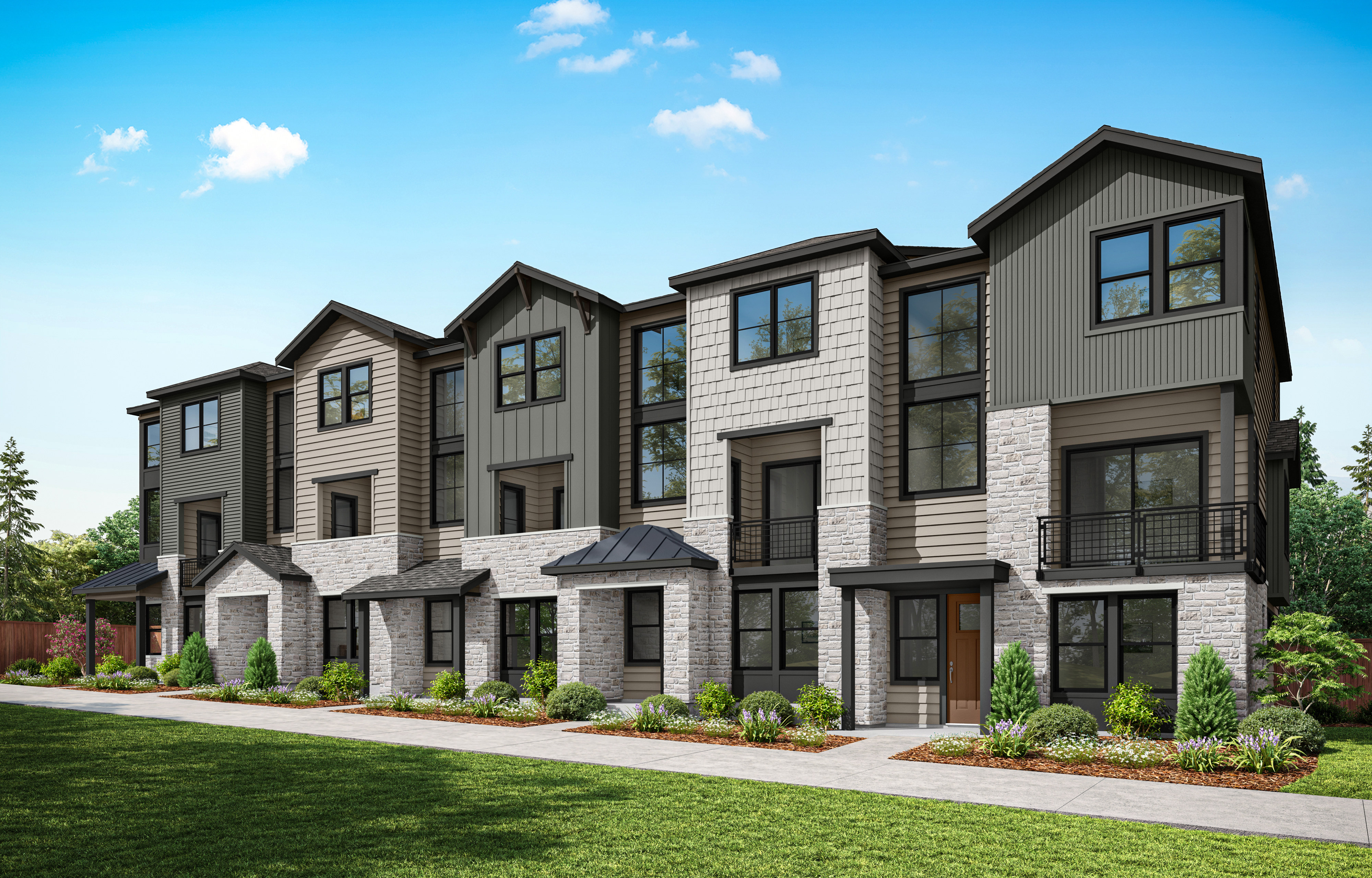 A row of modern, multi-story townhouses with gray siding and stone accents, set against a backdrop of a clear blue sky with fluffy white clouds, surrounded by a well-manicured lawn.