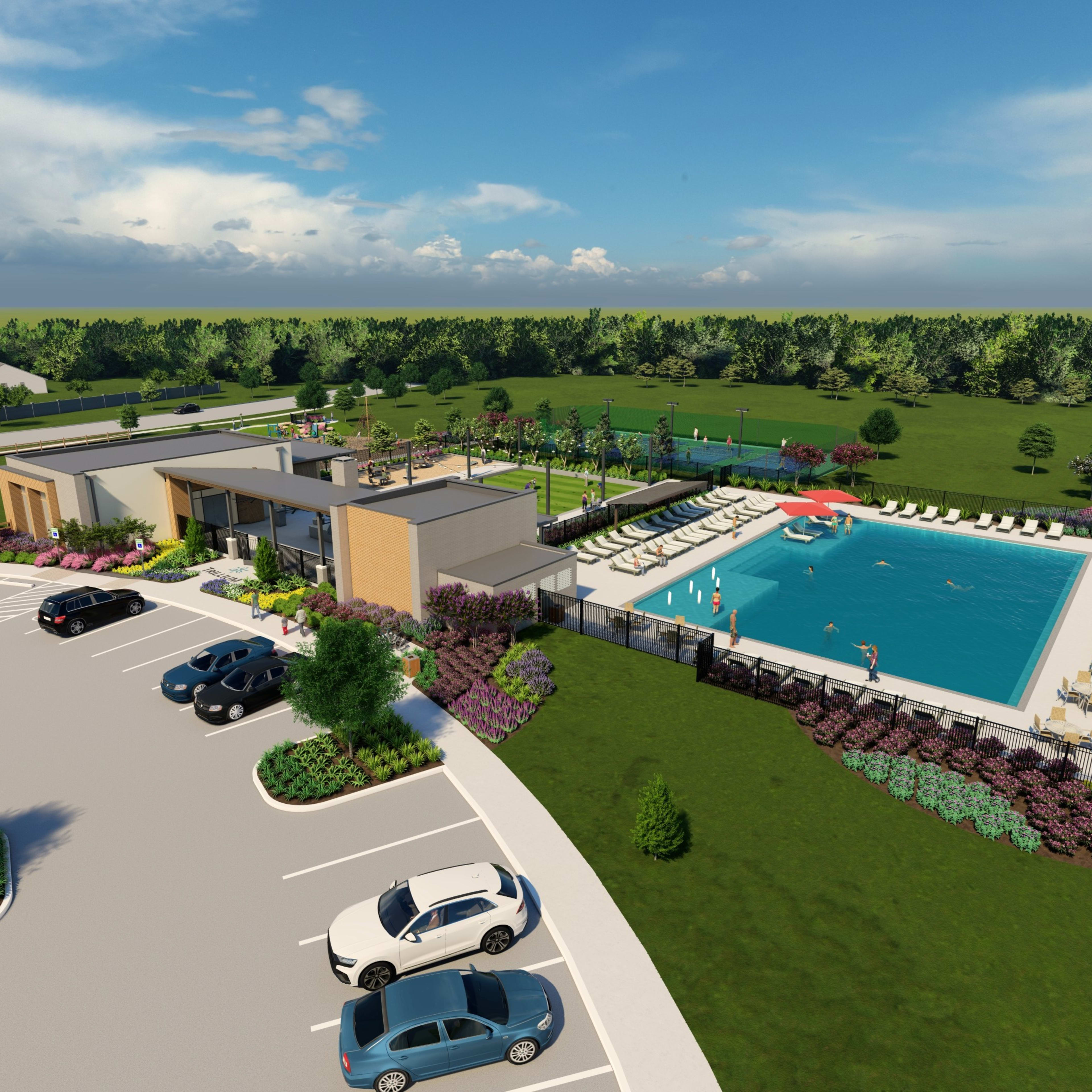 A lush, landscaped resort with a large outdoor swimming pool, surrounded by colorful flower beds and a forested area in the background.