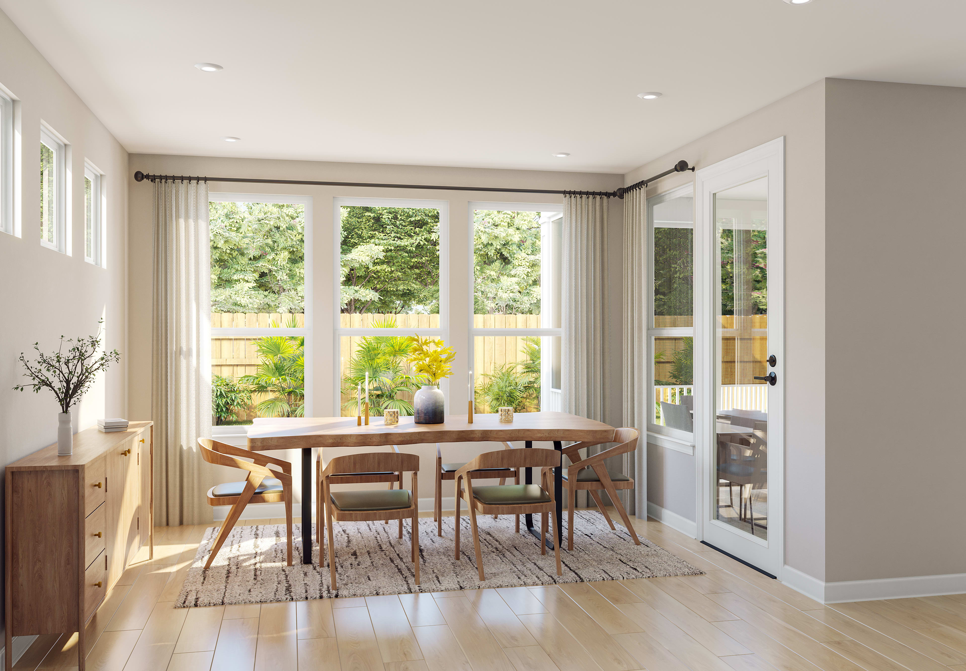 A bright and airy dining room with a wooden table and chairs, surrounded by large windows overlooking a lush outdoor garden.