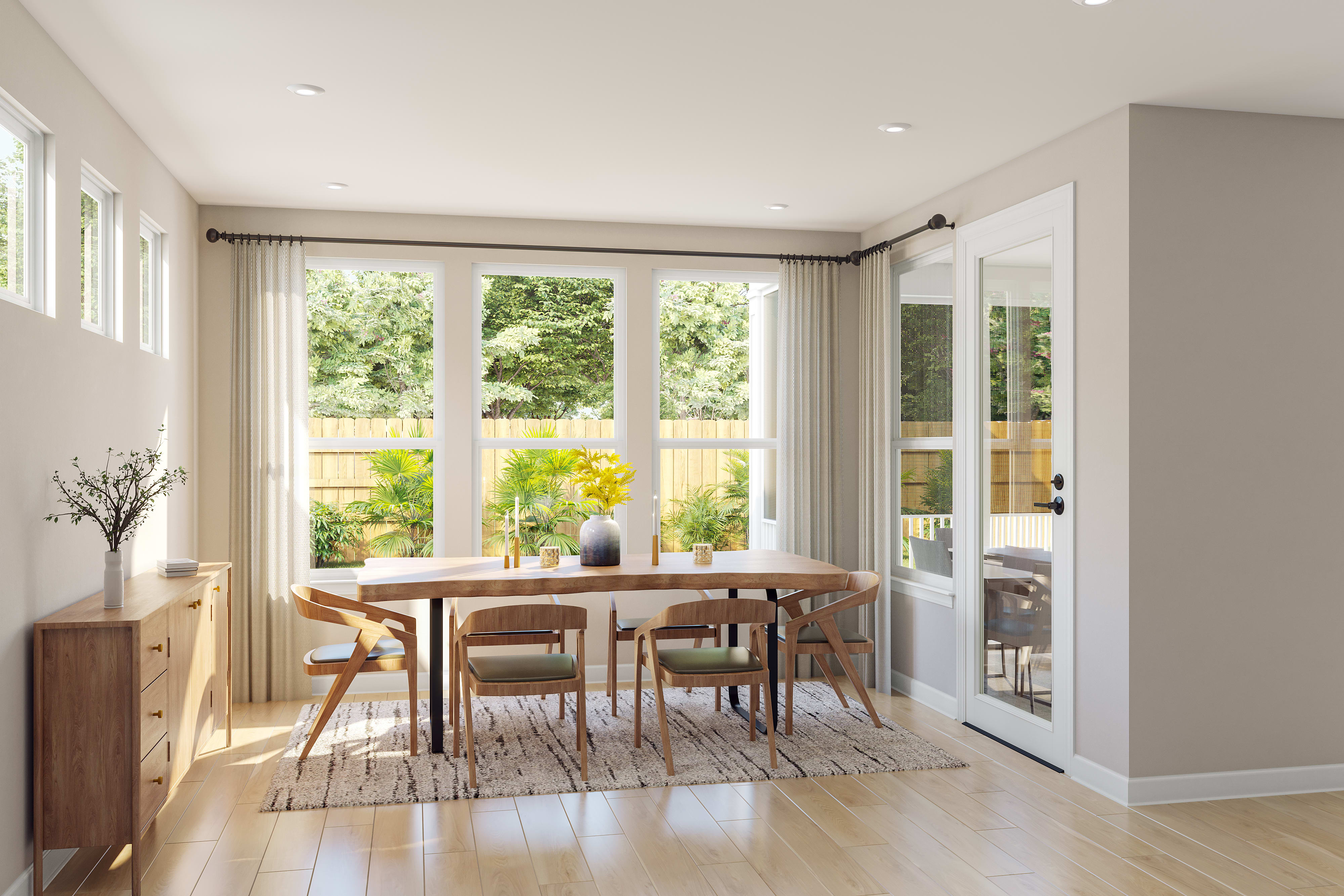 A bright and airy dining room with a wooden table and chairs, surrounded by large windows overlooking a lush outdoor garden.