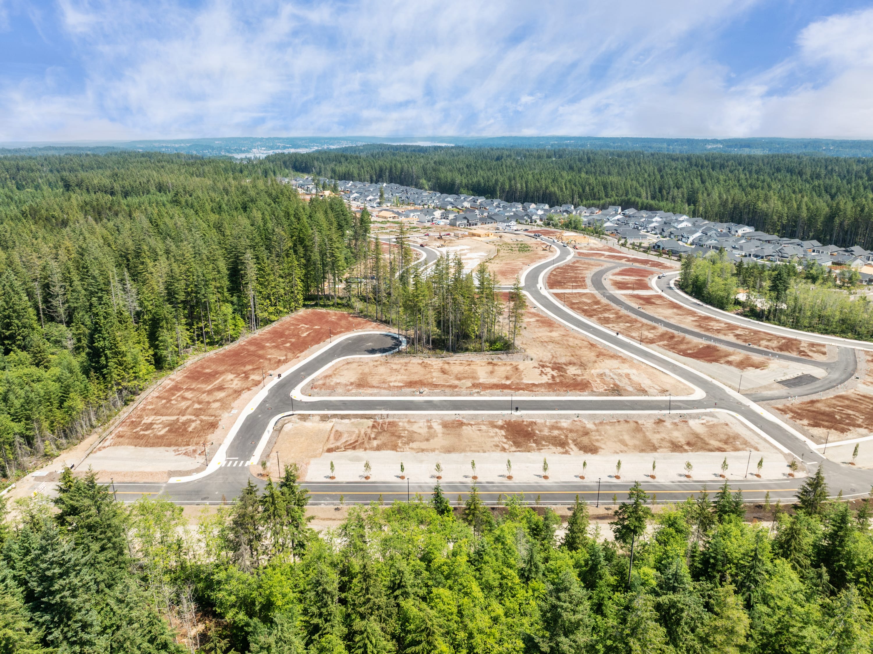 A sprawling network of roads and infrastructure nestled amidst a dense forest, with a small town visible in the distance.