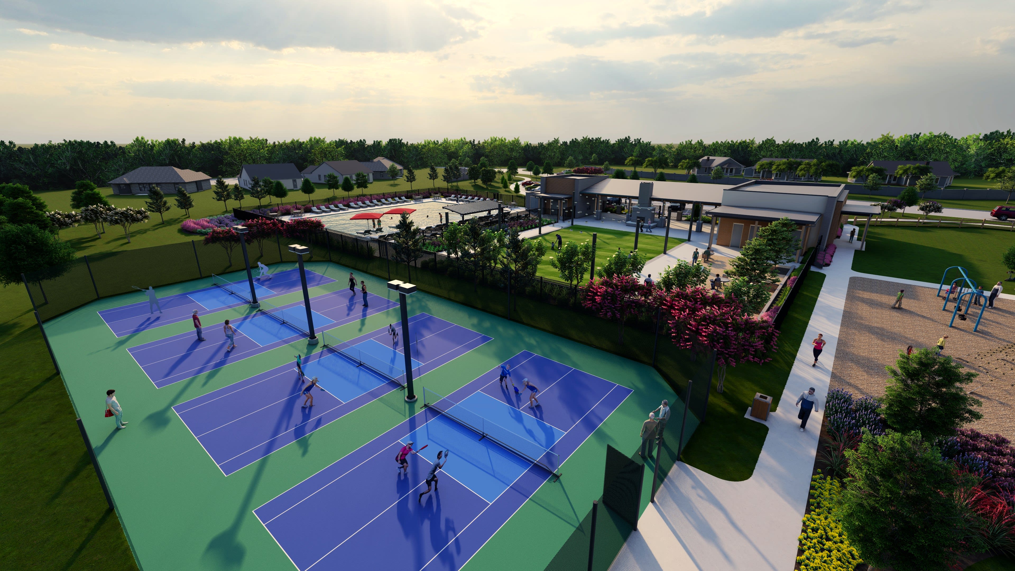 A vibrant outdoor recreational area with colorful tennis courts, lush greenery, and a cluster of buildings in the background.