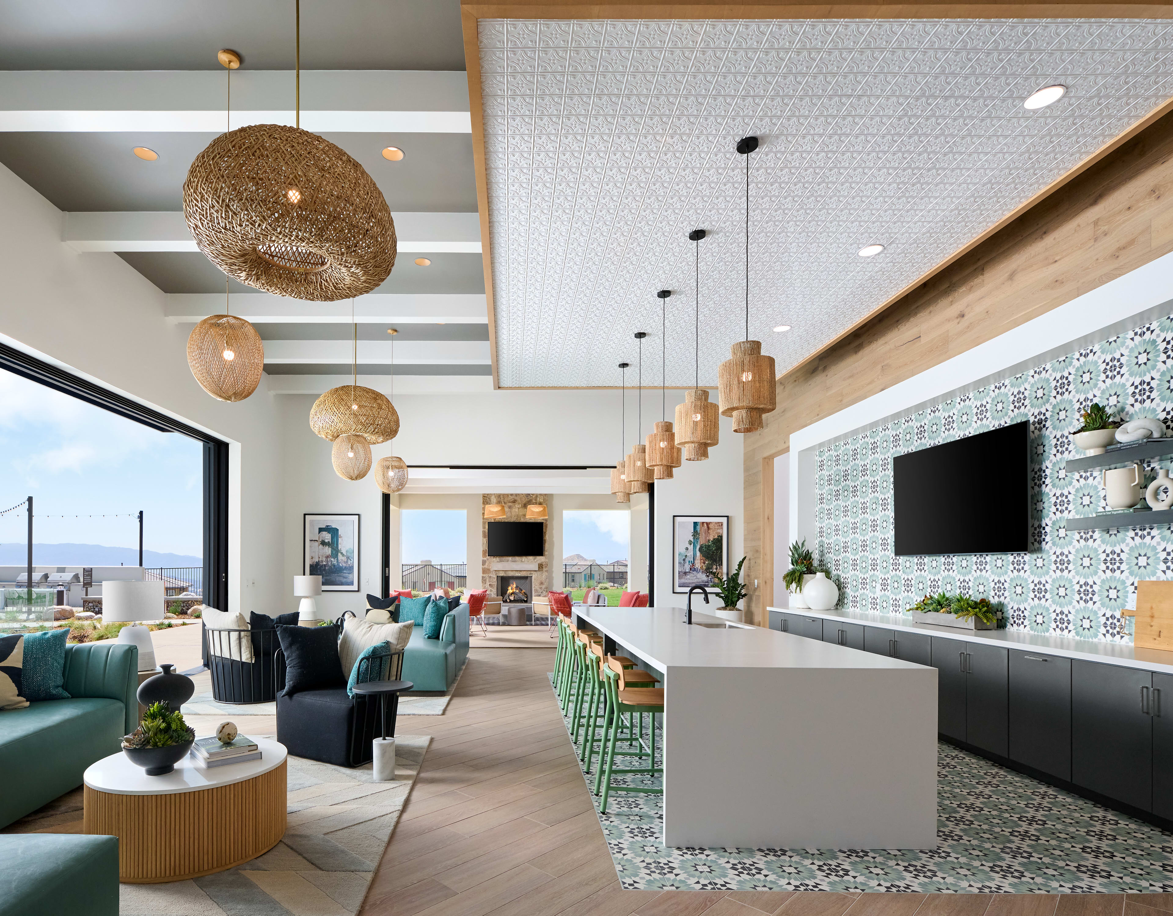 A modern and stylish living room with comfortable sofas, pendant lighting, and a scenic view through the large windows.