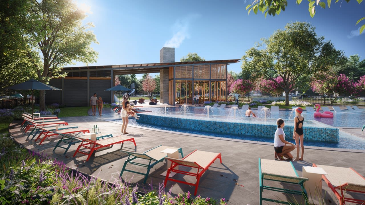 A vibrant outdoor pool area surrounded by lush greenery, with colorful lounge chairs and a wooden structure in the background.