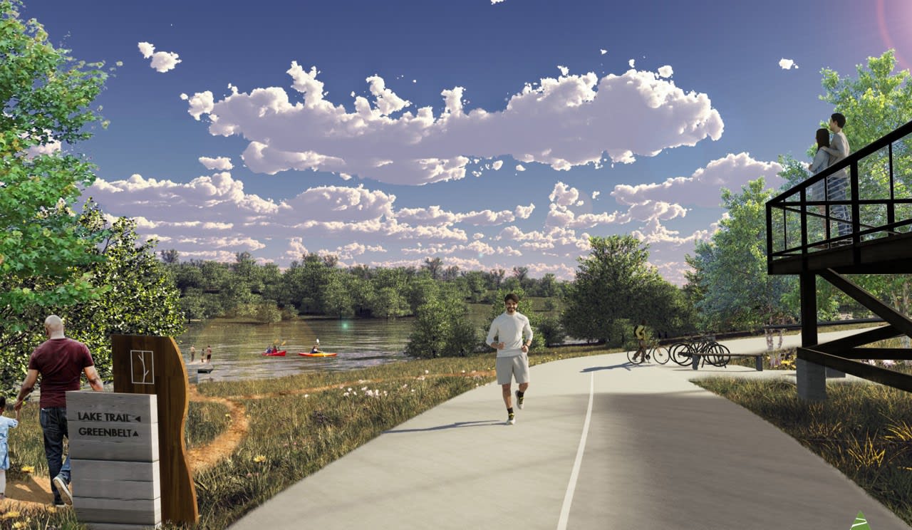 A scenic outdoor path runs along a river, with lush greenery and a cloudy sky in the background. A person can be seen walking on the path.