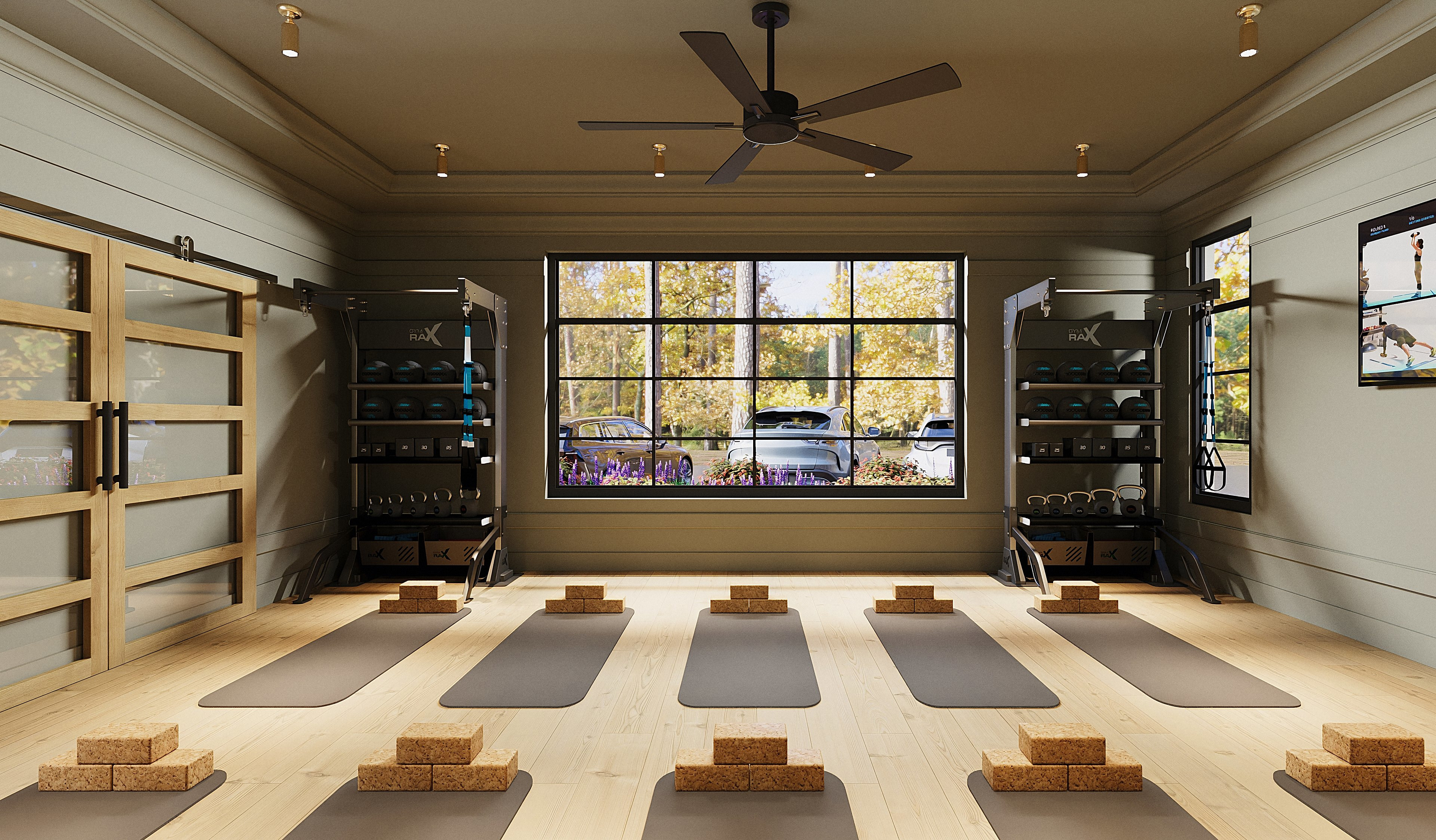 A spacious and well-lit yoga studio with wooden floors, shelves displaying various items, and a large window overlooking a scenic outdoor view.