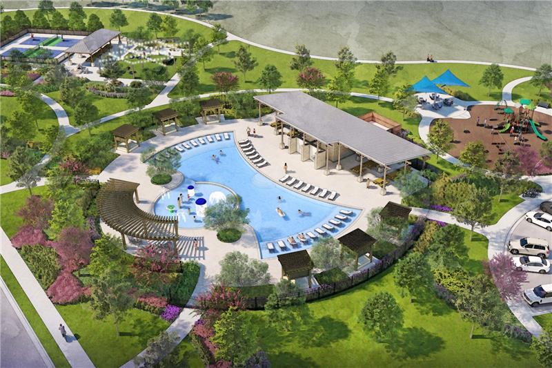 An aerial view of a lush, landscaped outdoor recreation area with a large swimming pool, surrounding buildings, and various amenities such as a playground and picnic areas set against a backdrop of verdant trees and greenery.