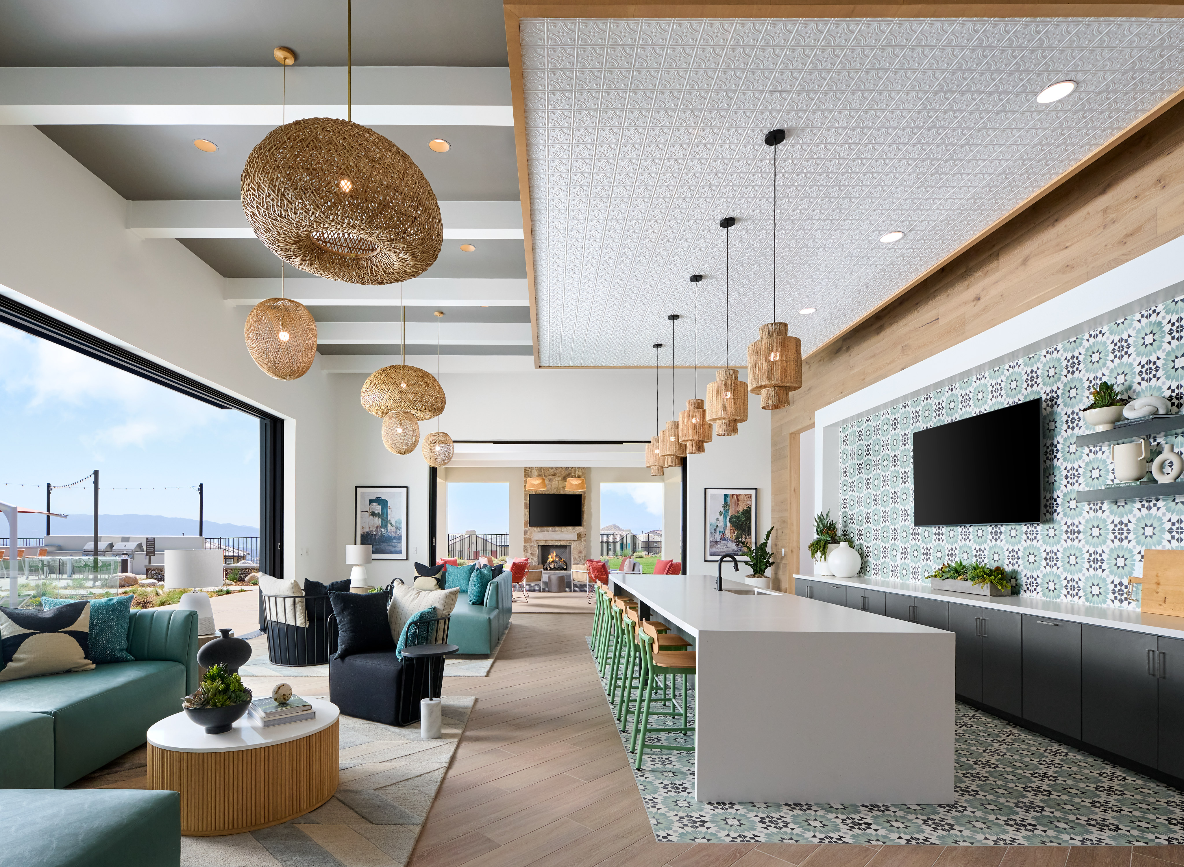 A modern and stylish living room with comfortable sofas, pendant lighting, and a scenic view through the large windows.