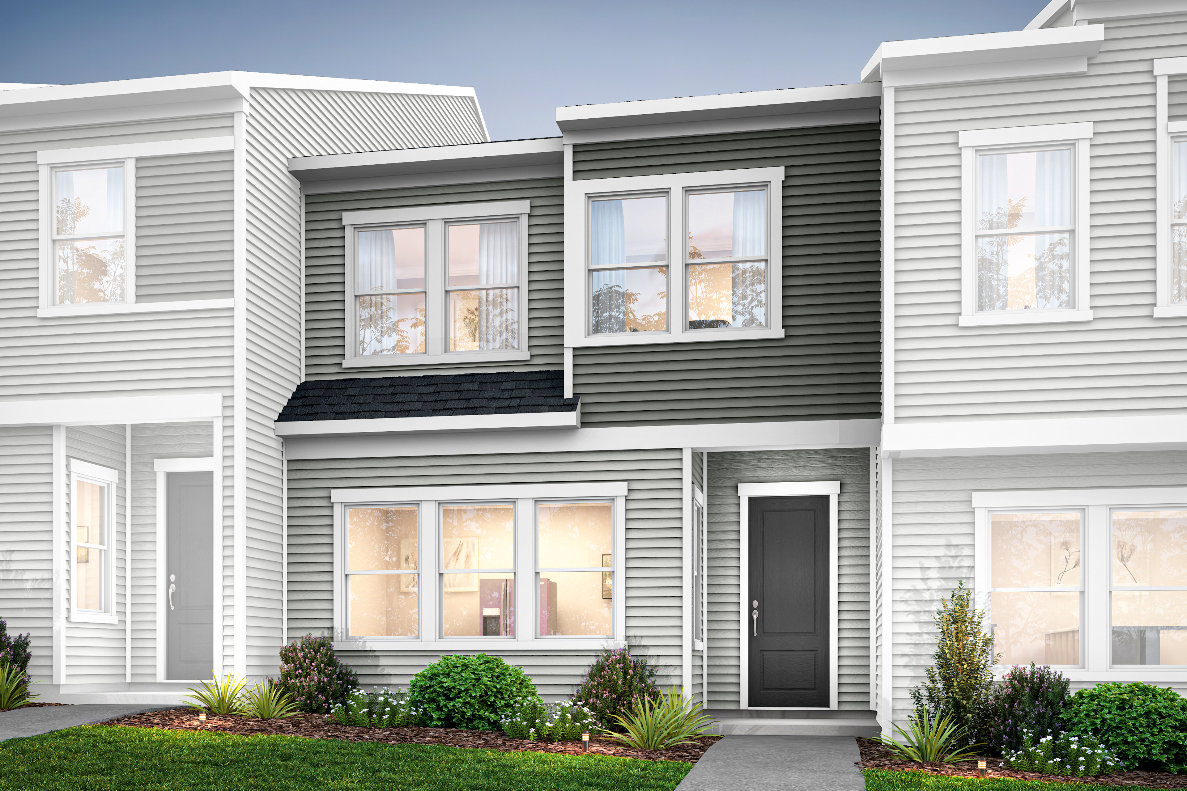 The image depicts a modern, multi-unit residential building with a clean, minimalist design featuring a mix of white and gray siding, large windows, and a well-landscaped front yard.
