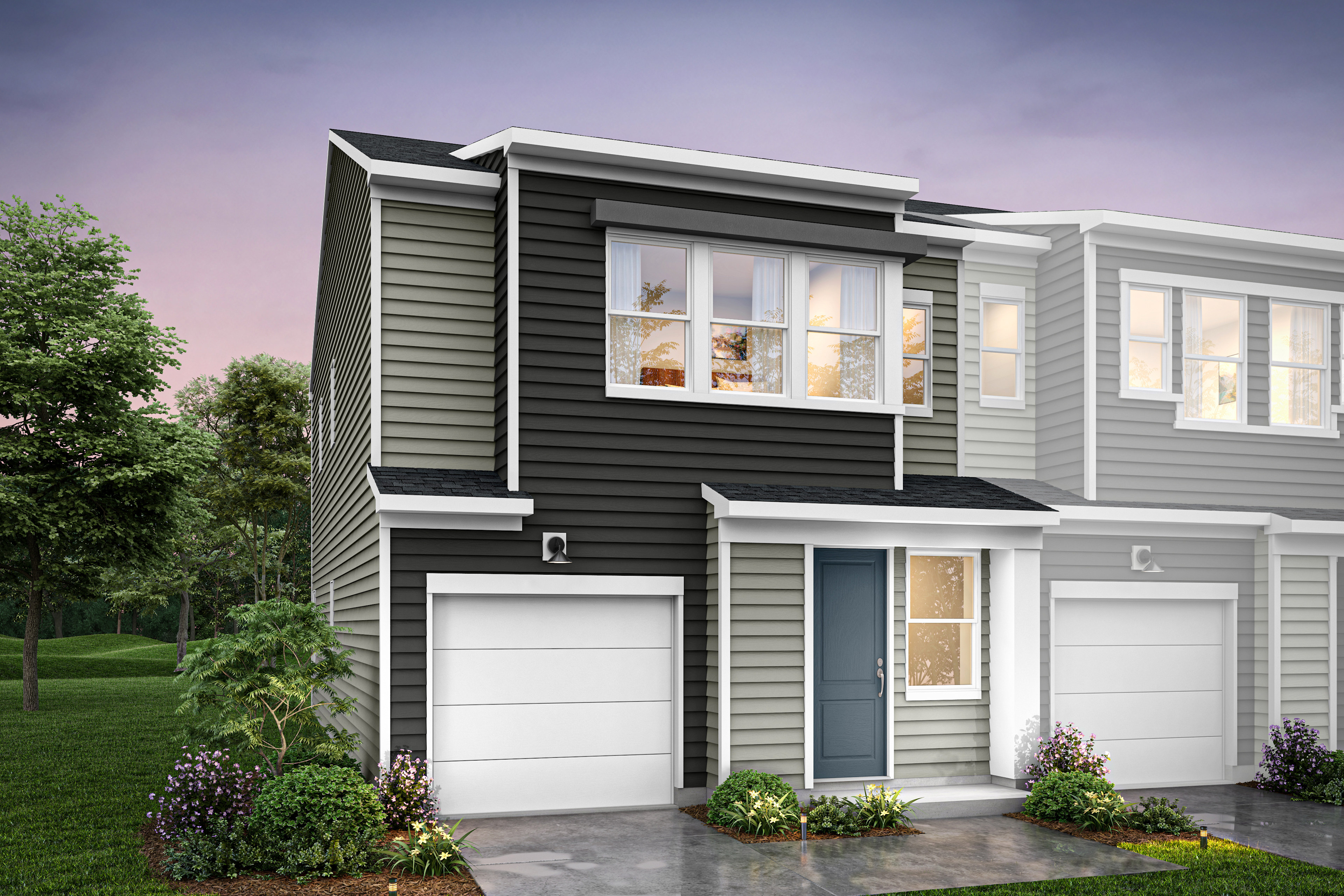 A modern two-story townhouse with a gray exterior, white trim, and a landscaped front yard featuring flowers and shrubs.