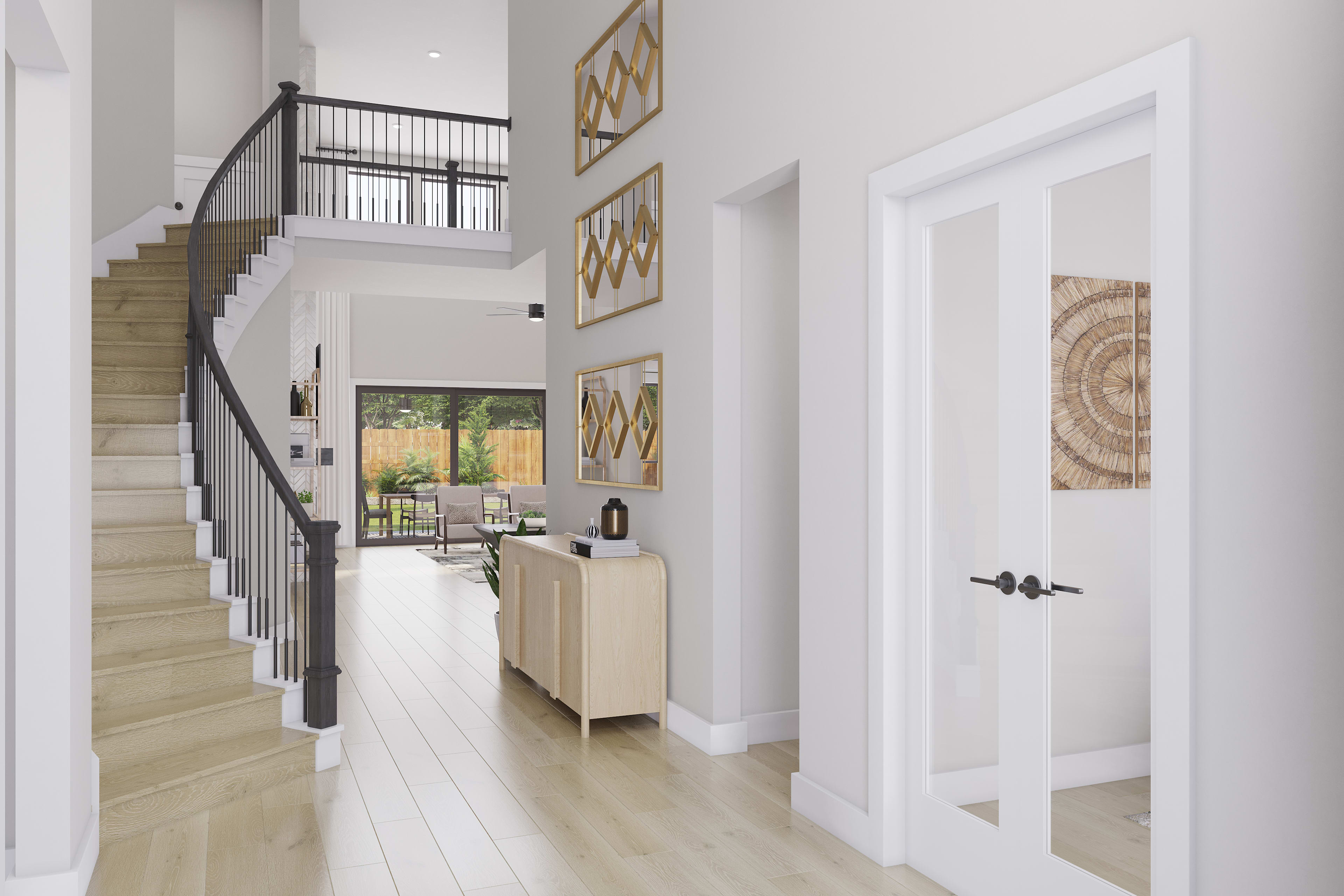 A bright and airy entryway with a wooden staircase, white walls, and decorative artwork on the walls, leading to a view of the outdoors through a glass door.