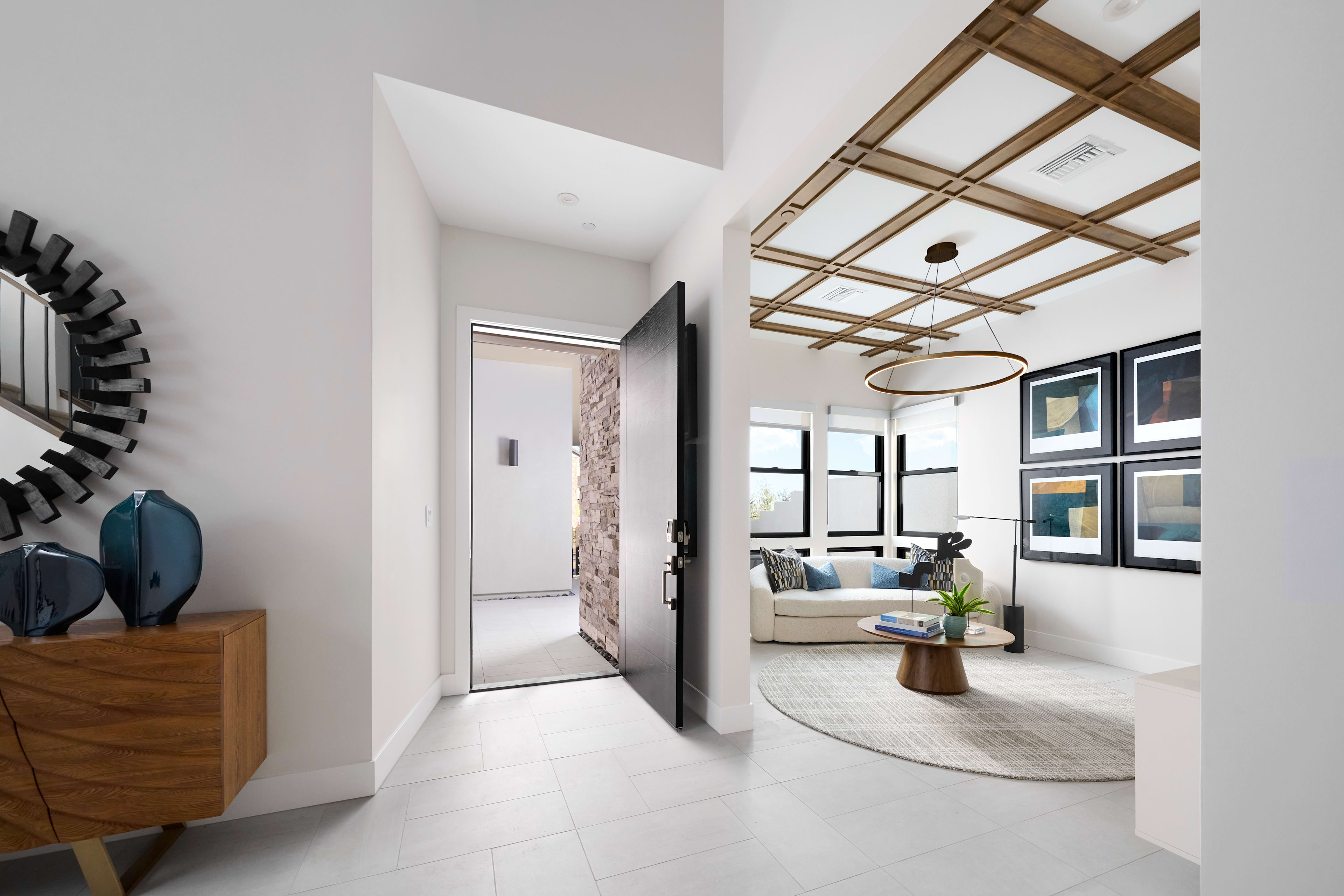 A modern and stylish interior design featuring a wooden ceiling with exposed beams, a cozy living room with a sofa, and a hallway leading to other rooms.
