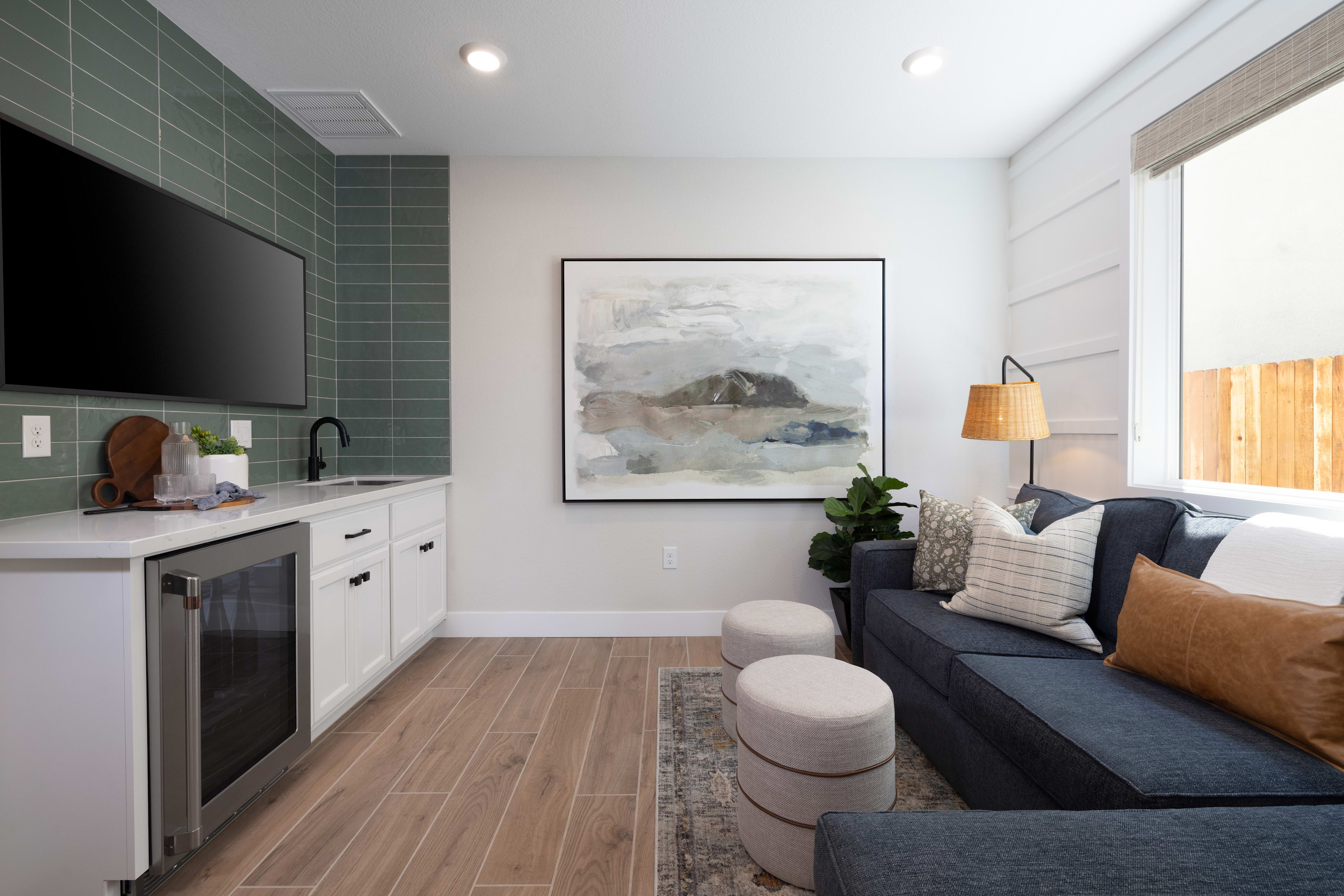 A modern and cozy living space with a kitchen area, a comfortable sofa, and a large abstract artwork on the wall.