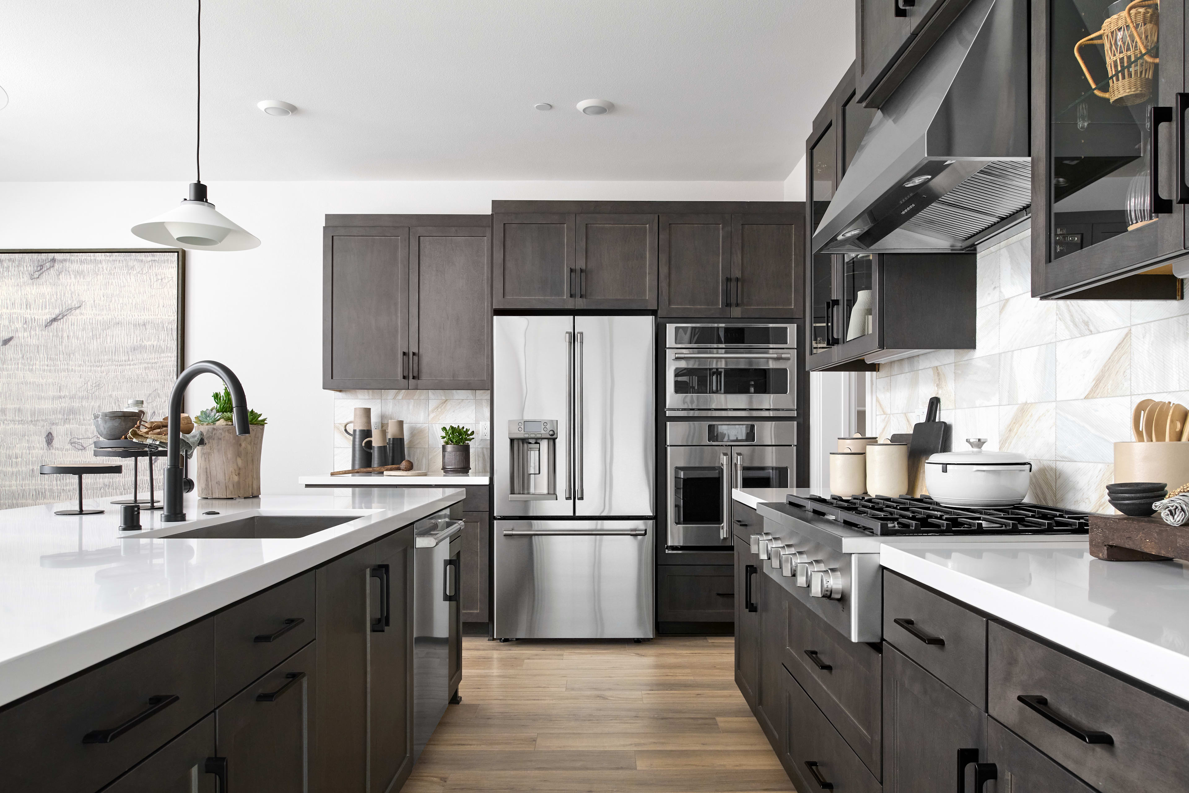 A modern, well-equipped kitchen with dark cabinets, stainless steel appliances, and a sleek, minimalist design.
