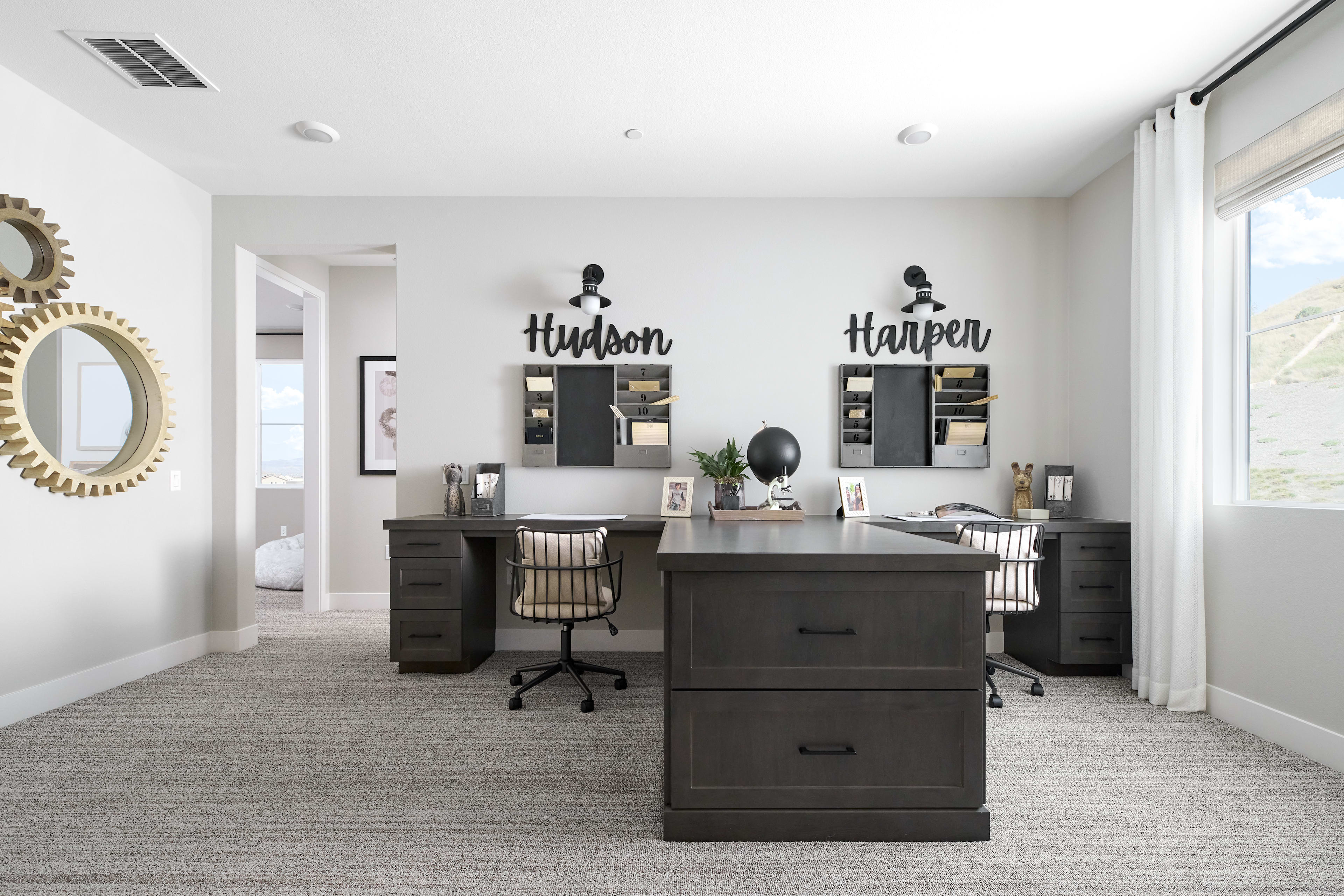 A modern and minimalist home office space with dark furniture, wall decor, and a bright, airy atmosphere.