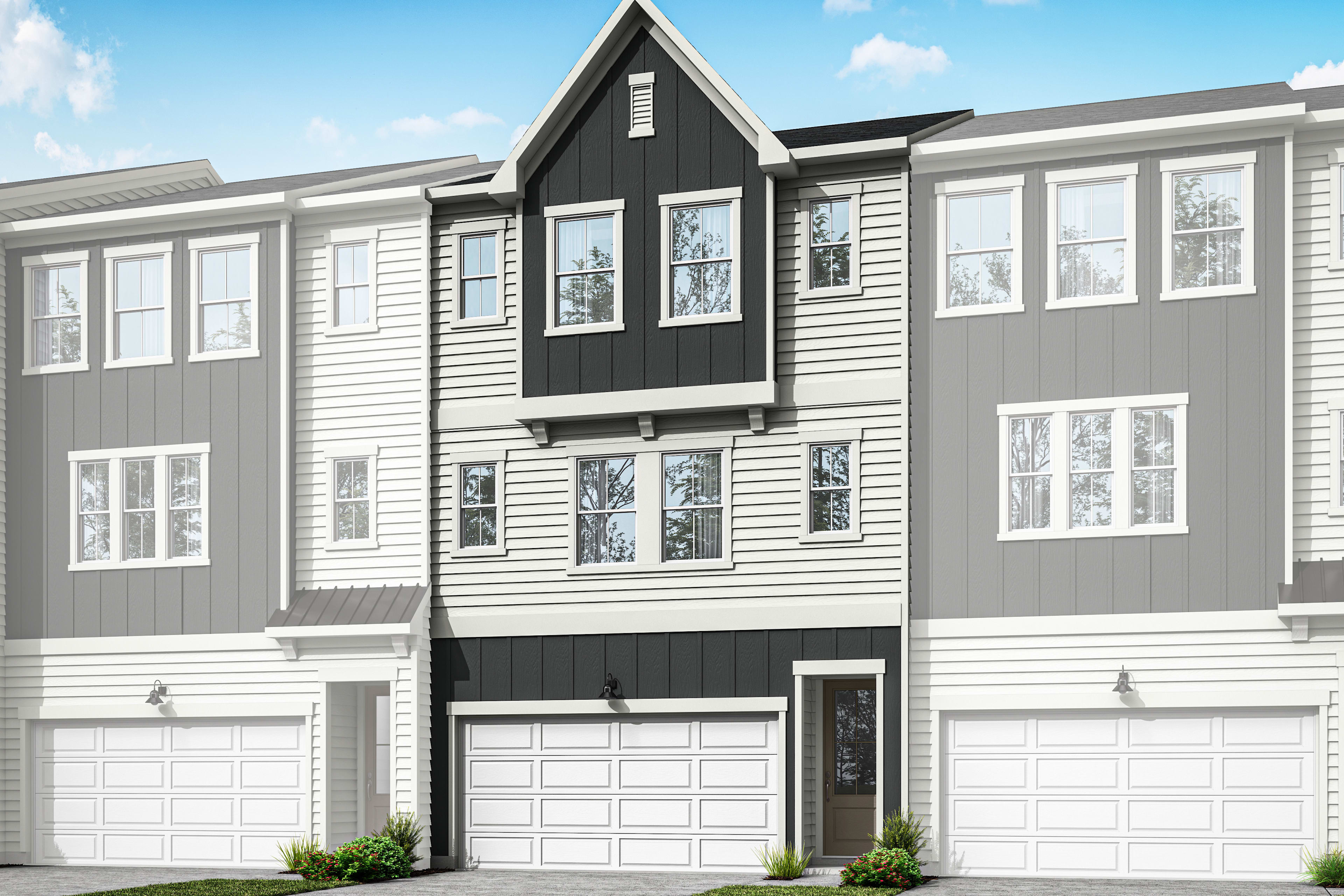 A modern, multi-story townhouse with a gray and white exterior, featuring a prominent triangular roof and a driveway leading to a garage door in the foreground, set against a blue sky with scattered clouds.