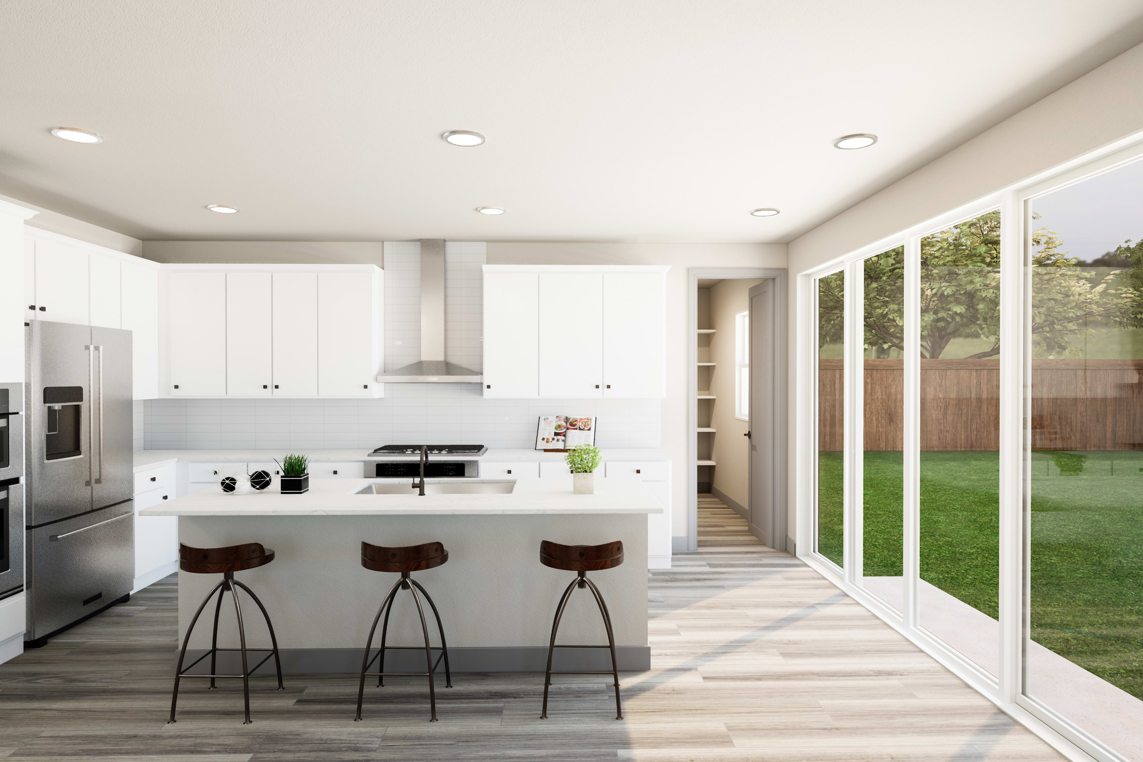 A modern, open-concept kitchen with white cabinets, stainless steel appliances, and a sliding glass door leading to a grassy backyard.