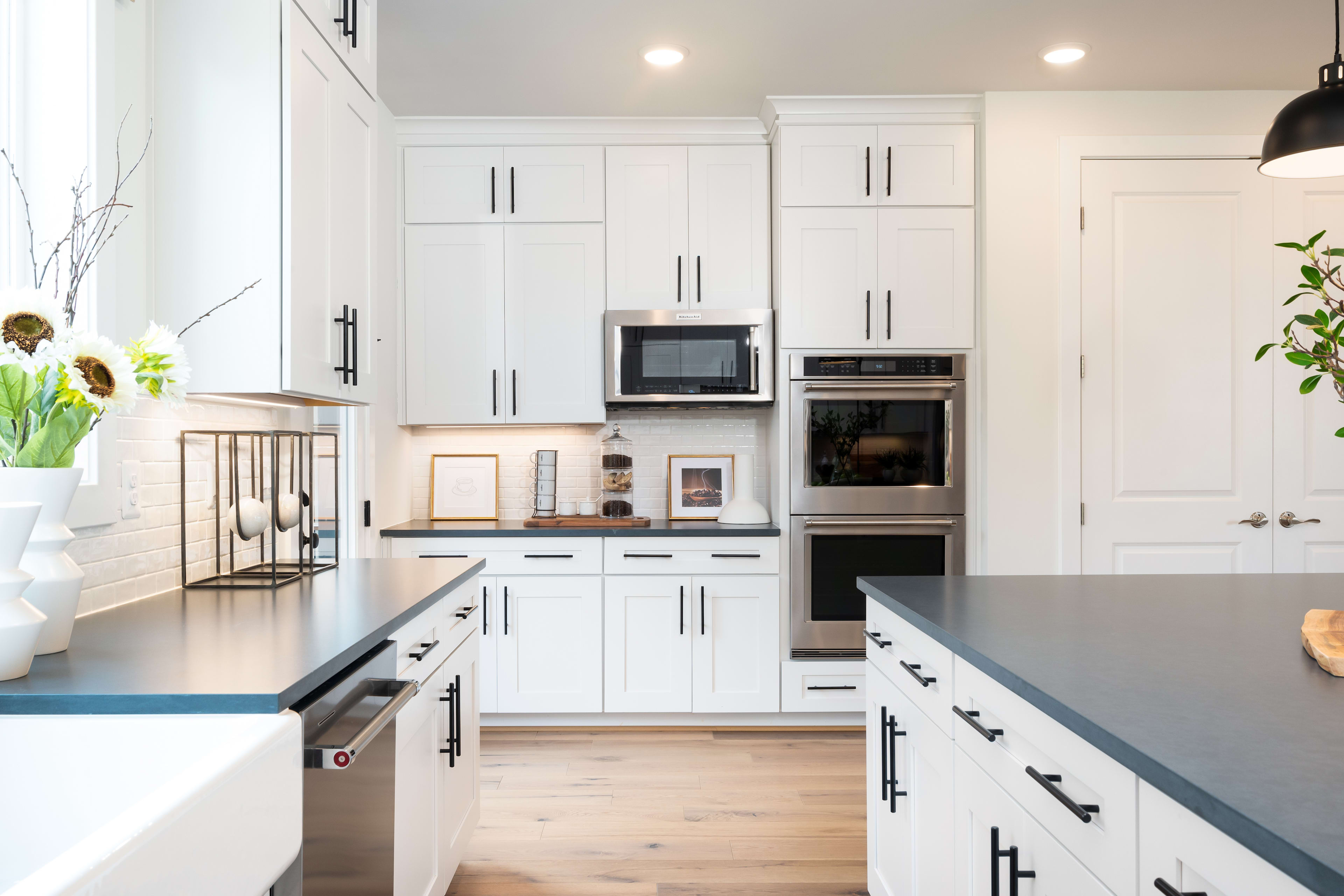 A modern, well-equipped kitchen with white cabinets, stainless steel appliances, and a sleek, minimalist design.