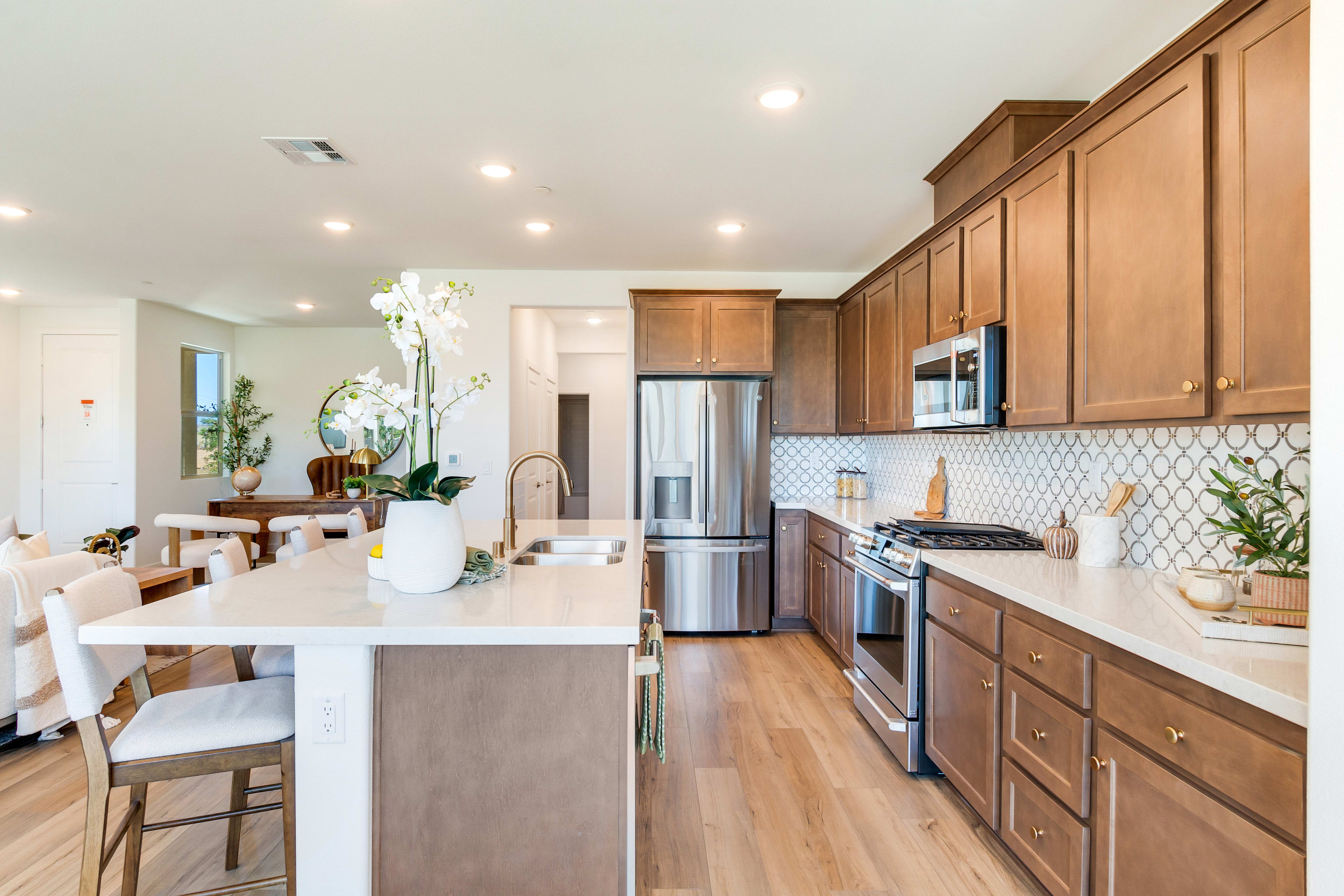 A modern and well-appointed kitchen with wooden cabinets, stainless steel appliances, and a dining area with a wooden table and chairs.