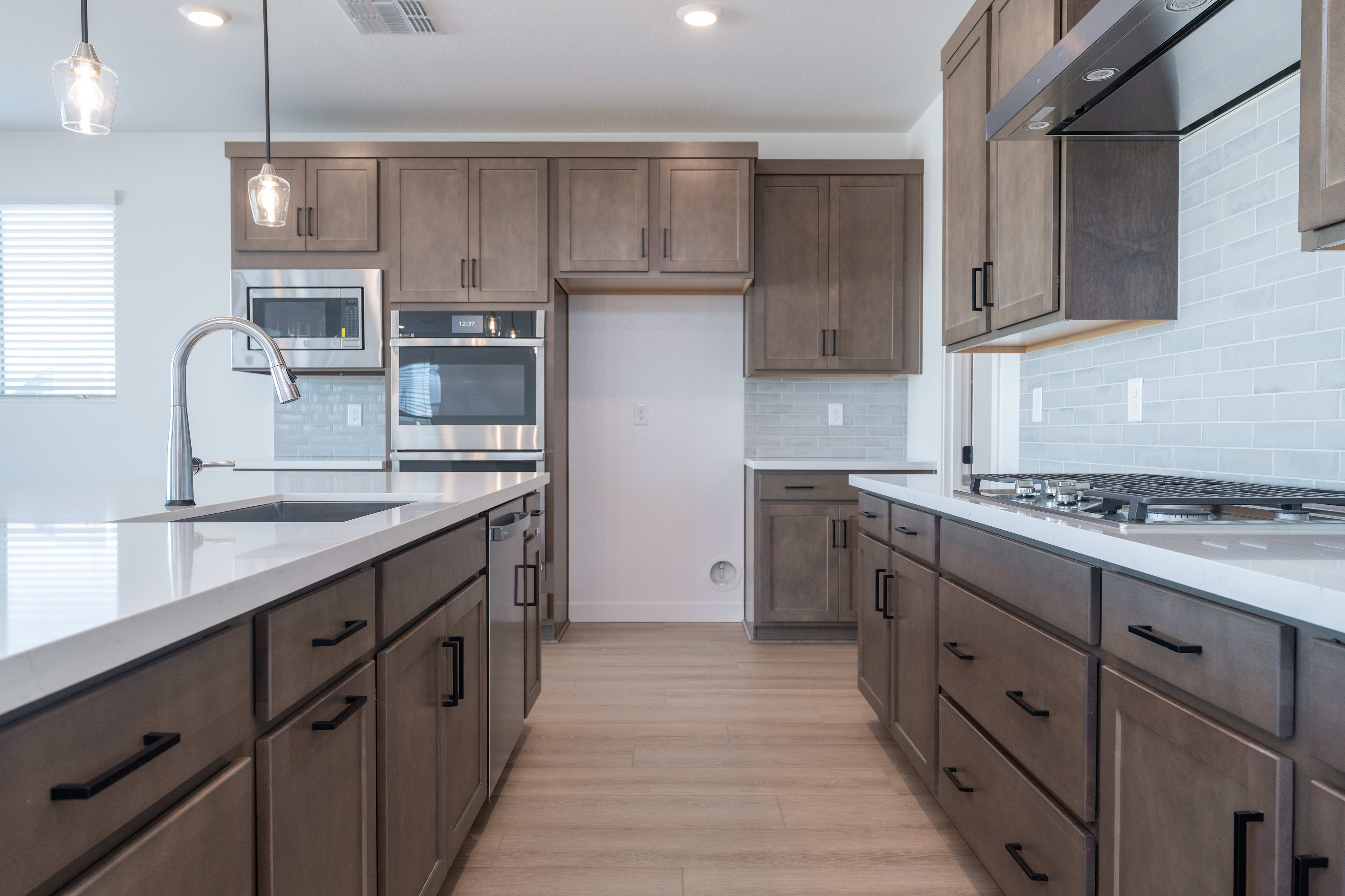 A modern, well-equipped kitchen with dark wood cabinets, stainless steel appliances, and a sleek, minimalist design.