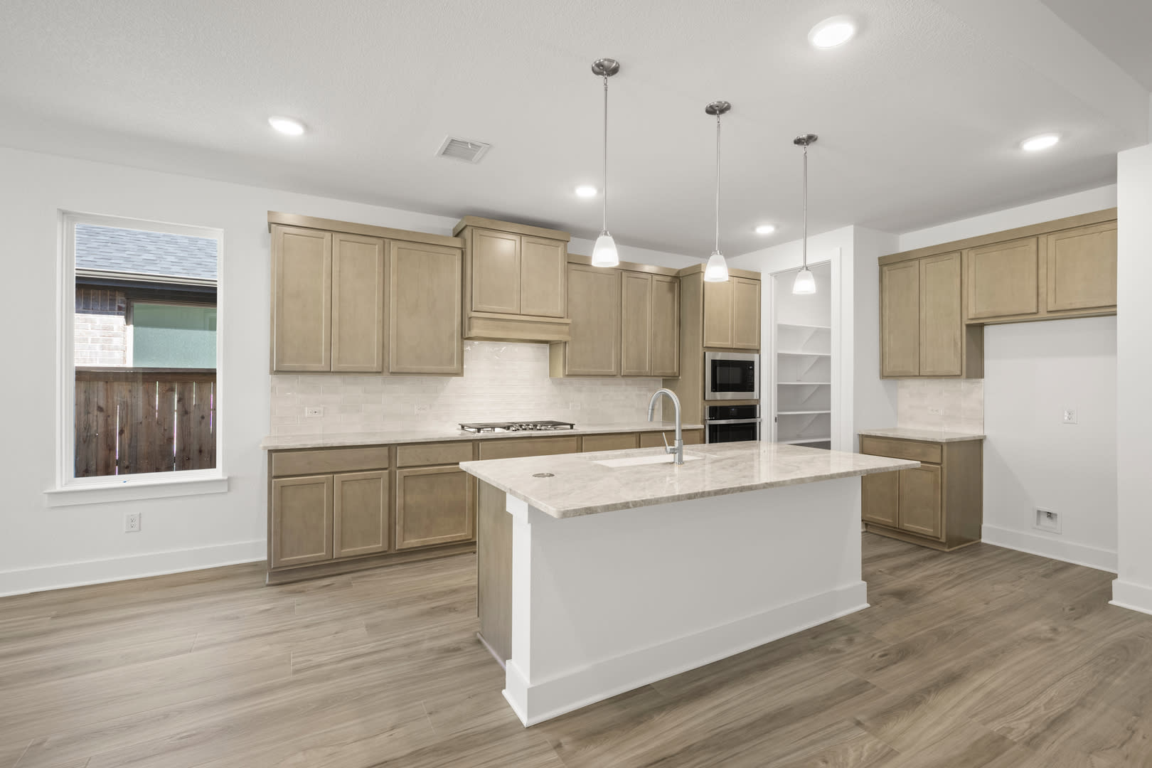 A modern, open-concept kitchen with light-colored cabinets, a white island, and hardwood flooring, set against a bright and airy background.