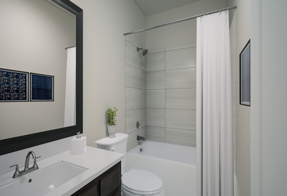 A modern, minimalist bathroom with a white vanity, toilet, and a shower curtain covering the bathtub. The walls are painted a light gray, and there are framed artworks on the wall.
